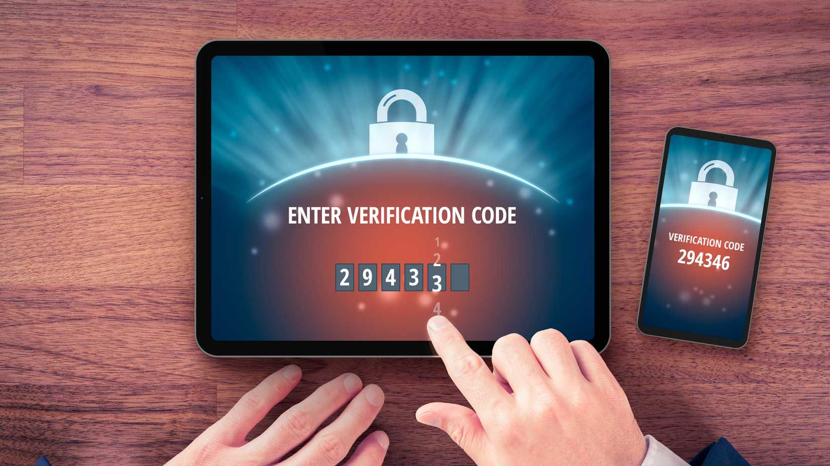 Человек вводит код двухфакторной аутентификации на планшете.