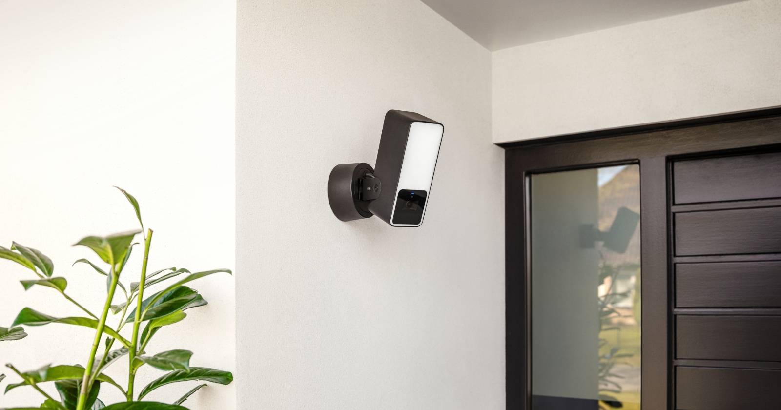 Наружная камера Eve рядом с дверью на фасаде дома