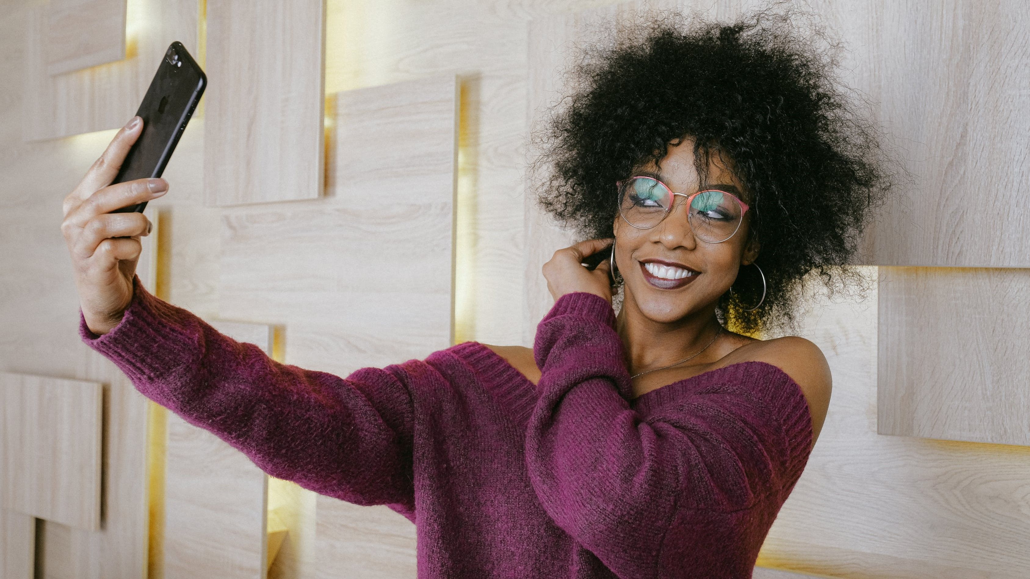 Женщина делает селфи у белой стены