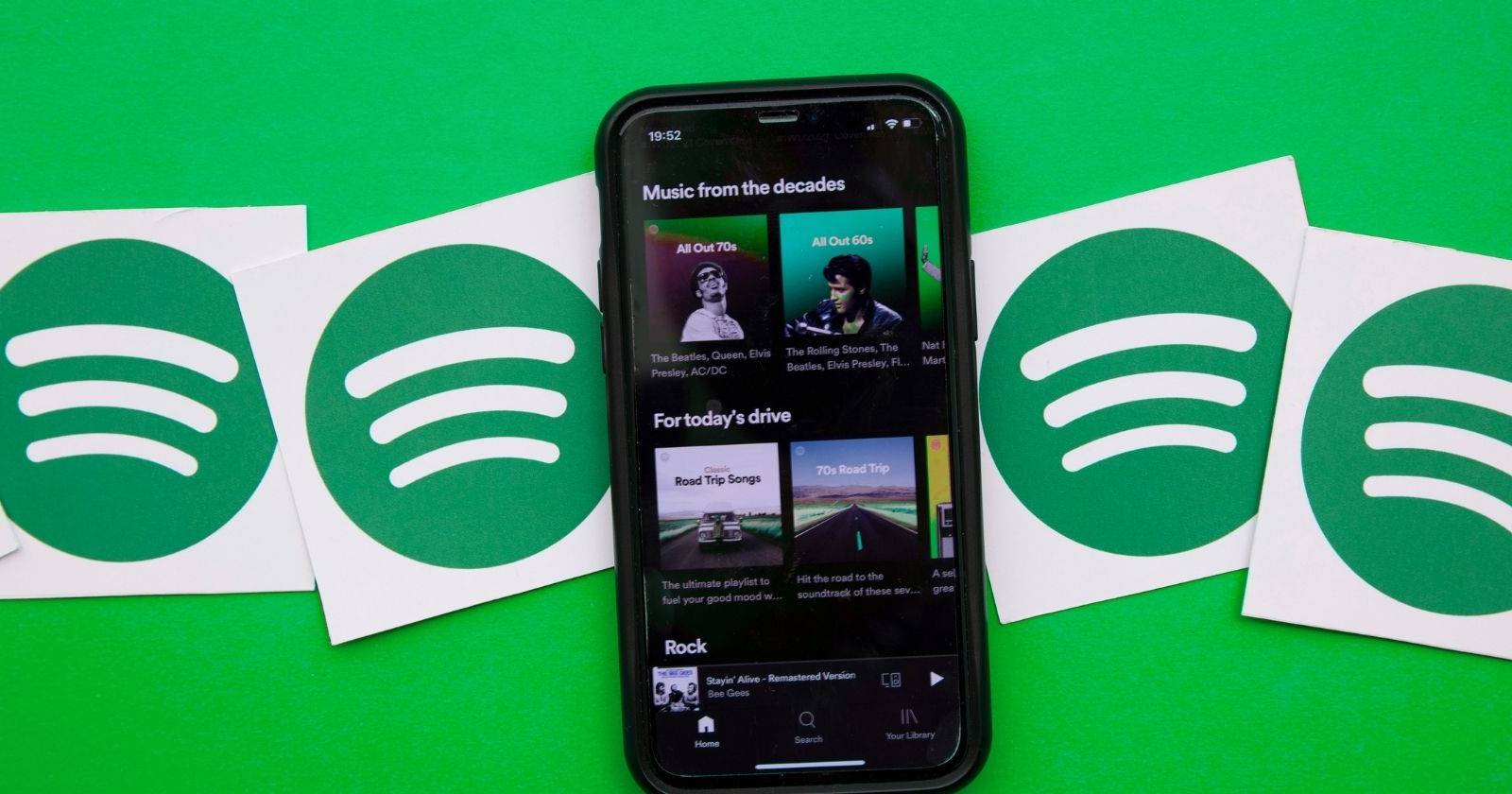 Смартфон с запущенным приложением Spotify и иконками сервиса вокруг