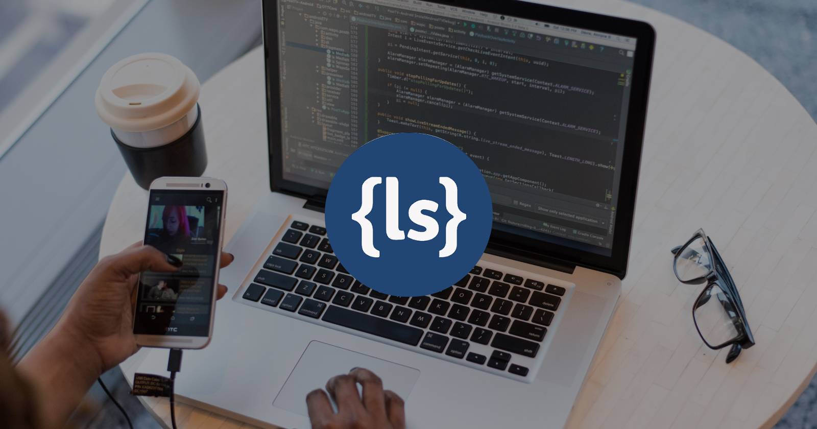 Логотип Less CSS на фоне человека, работающего за MacBook