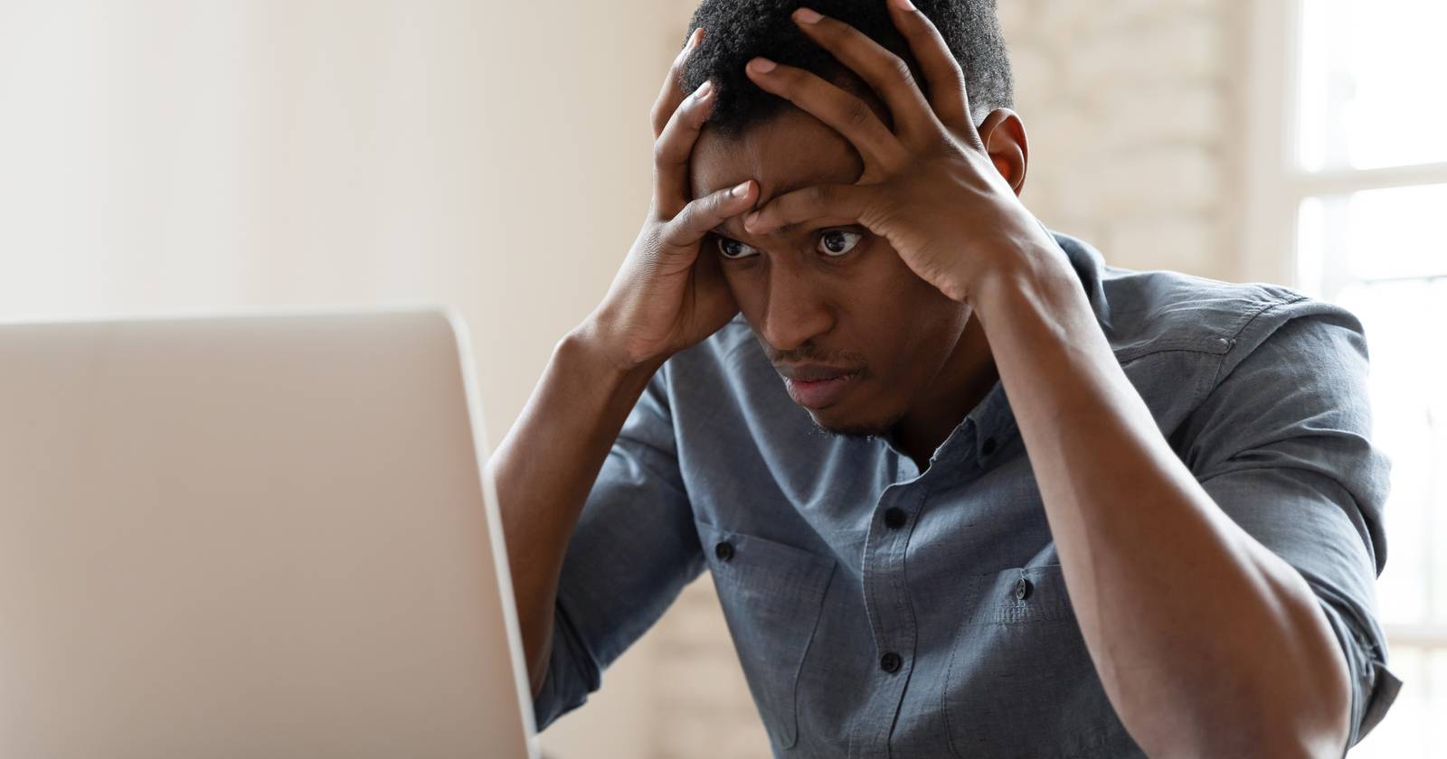 мужчина, раздражённо смотрящий на ноутбук