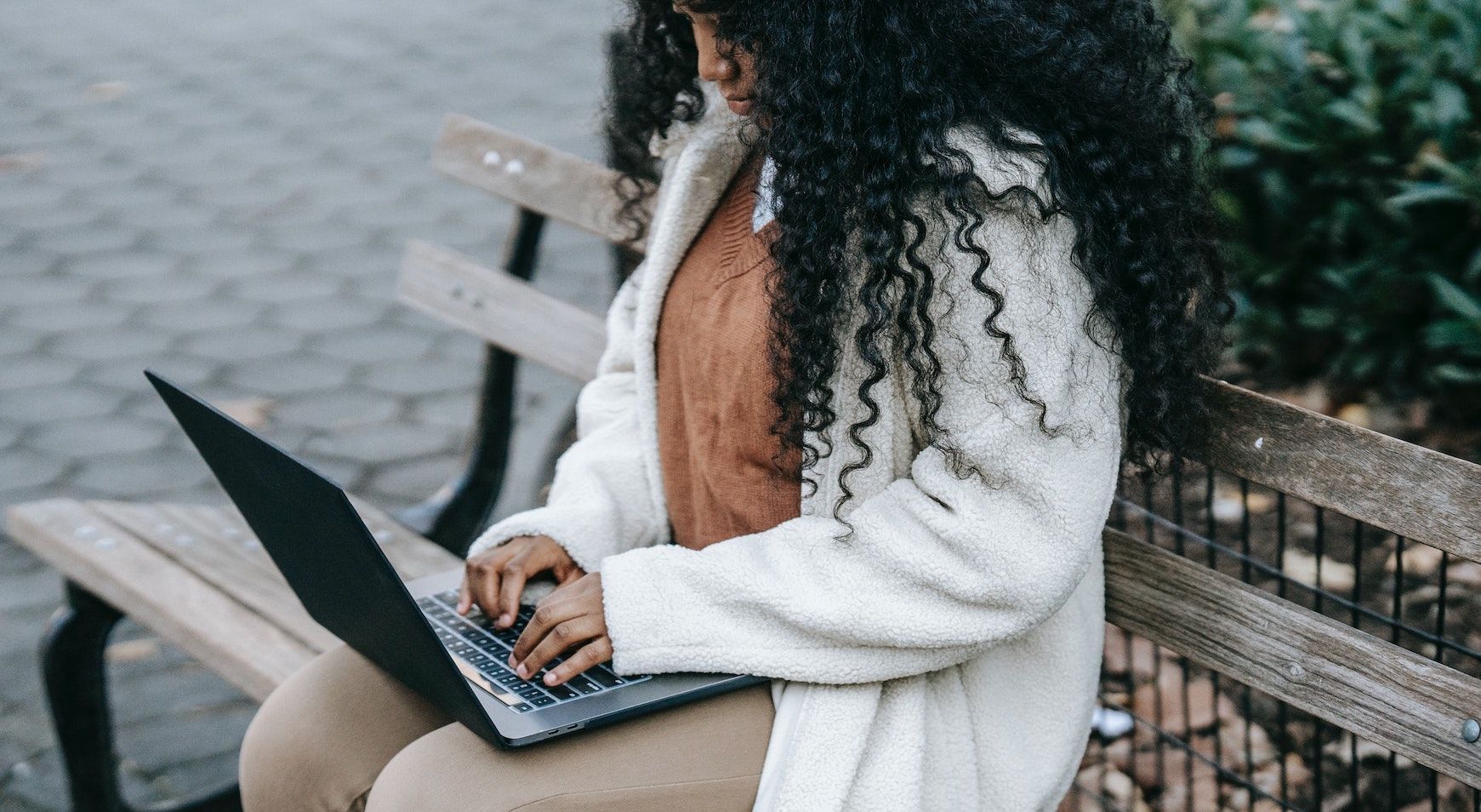 Женщина просматривает ноутбук на улице