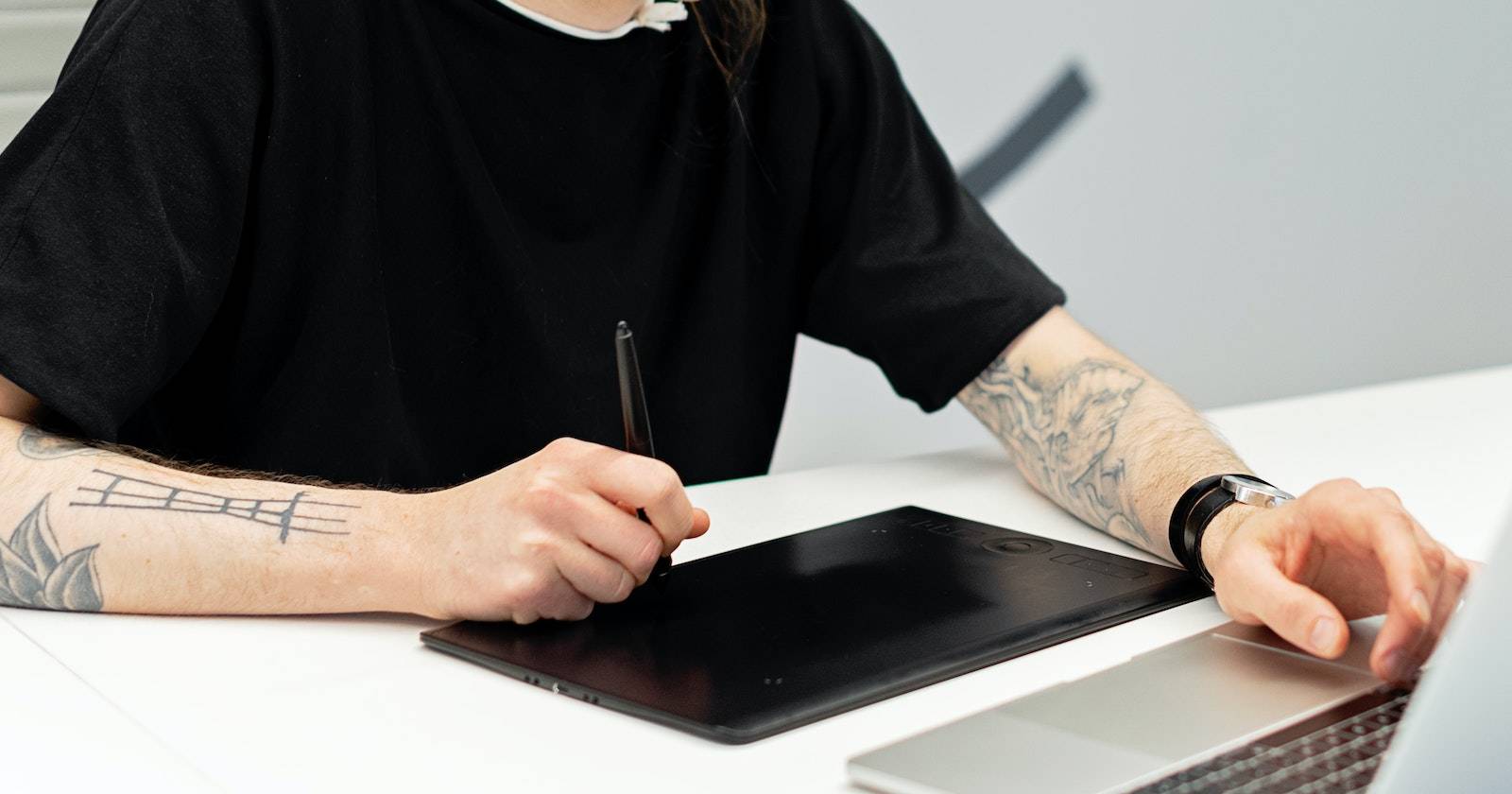 мужчина использует графический планшет и рисует на ноутбуке