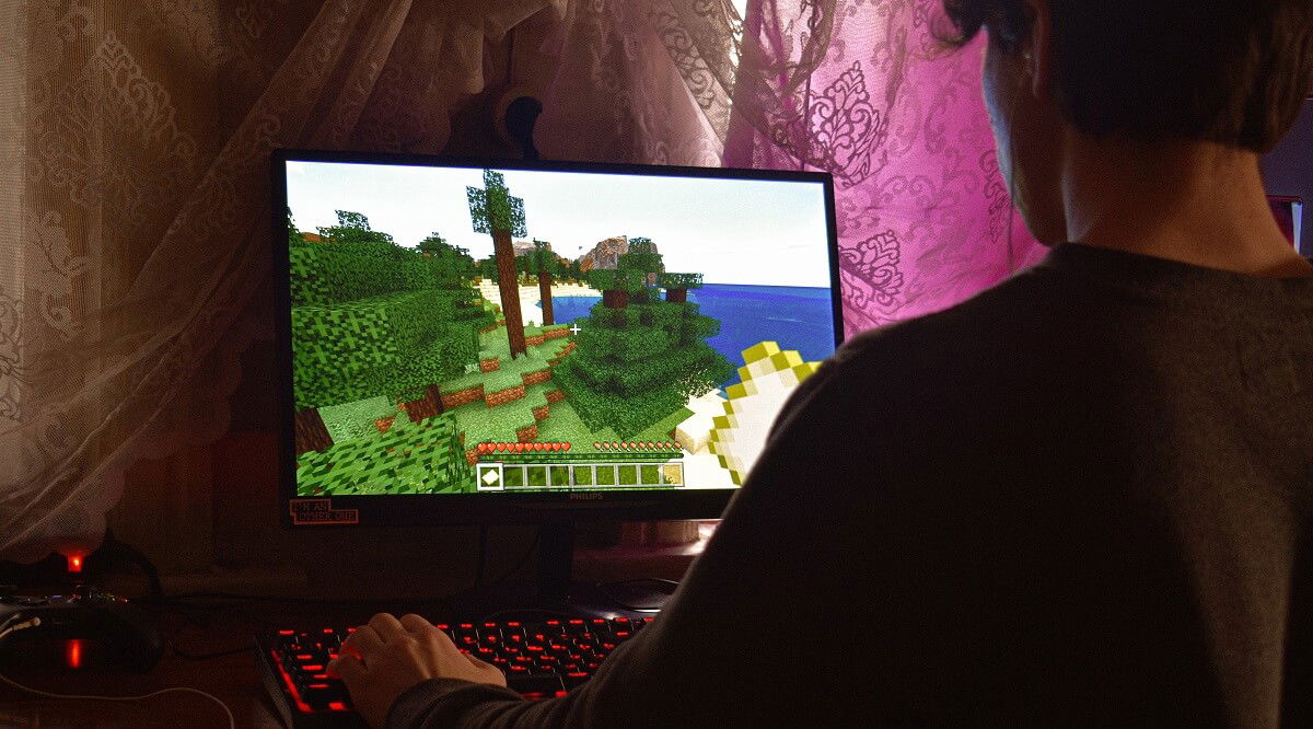 Геймер играет в Minecraft на игровом ПК