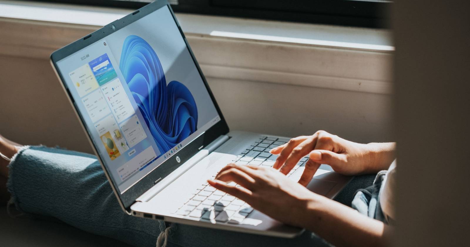 Человек работает за ноутбуком с Windows 11