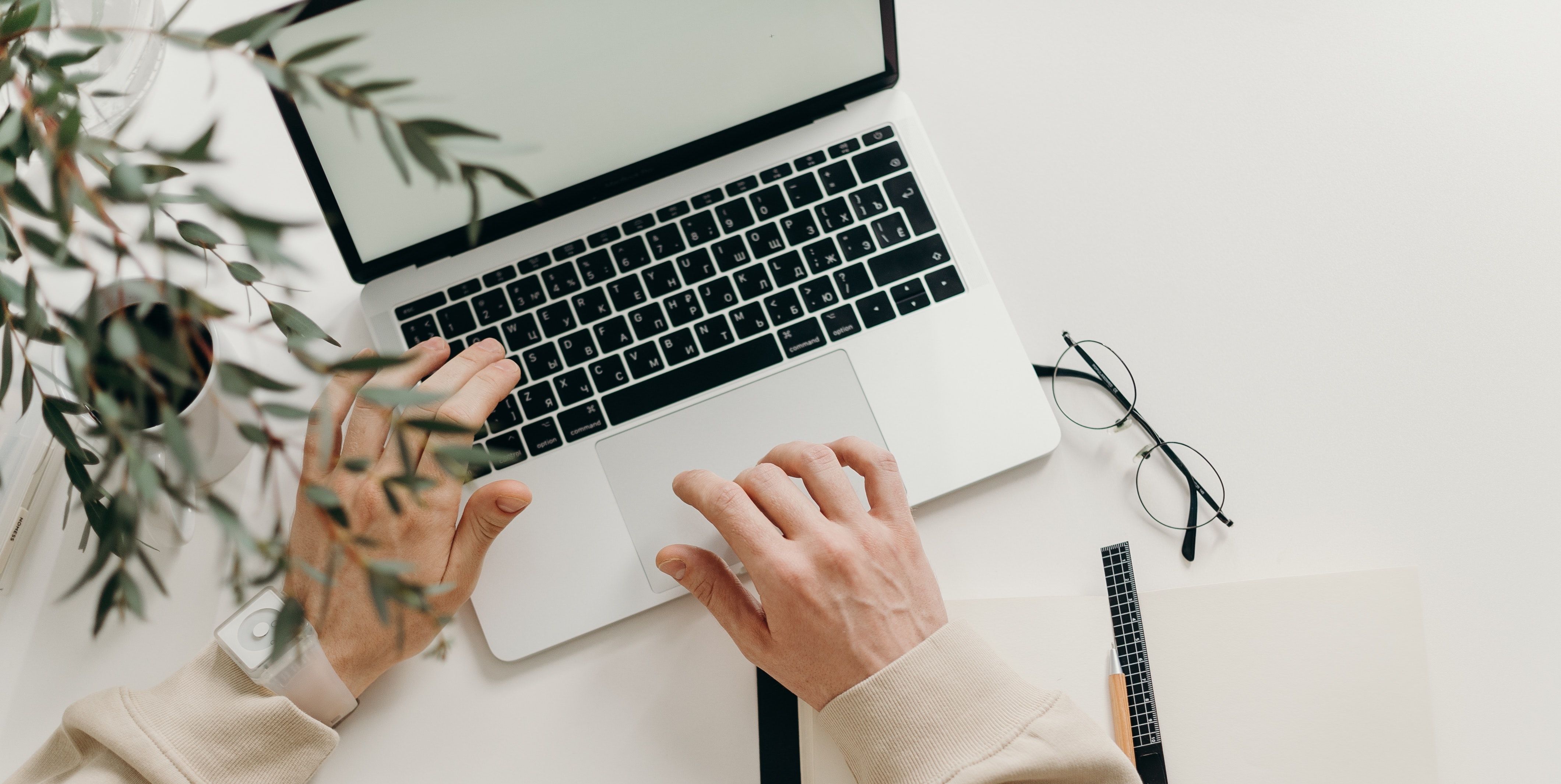 Две руки касаются MacBook на столе