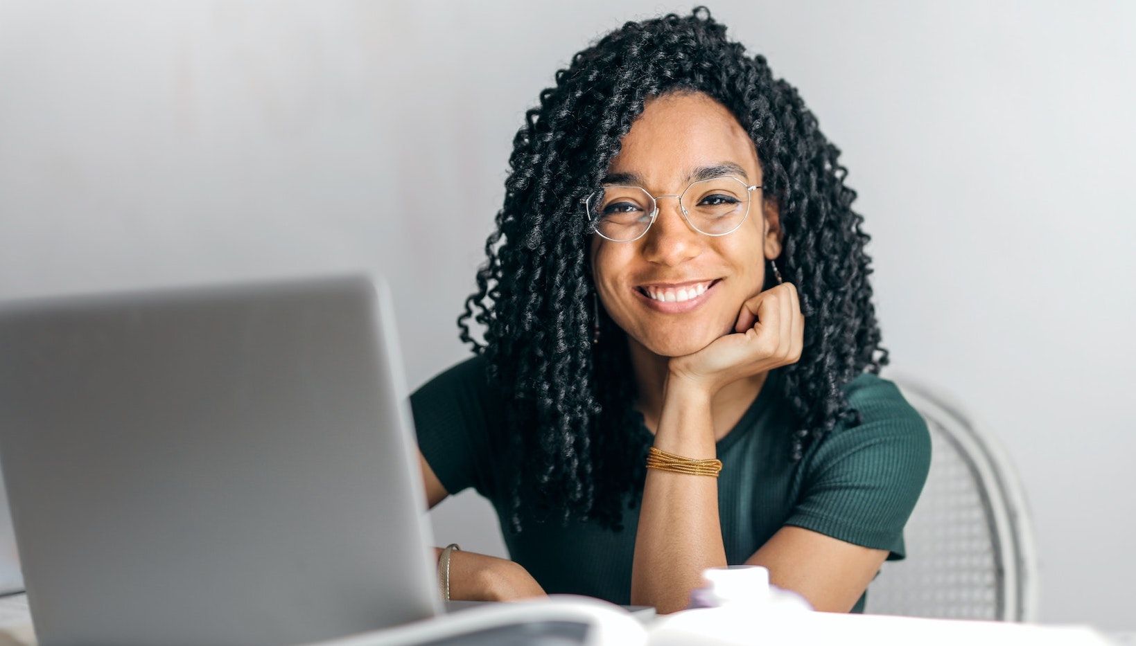 Молодая женщина улыбается за ноутбуком