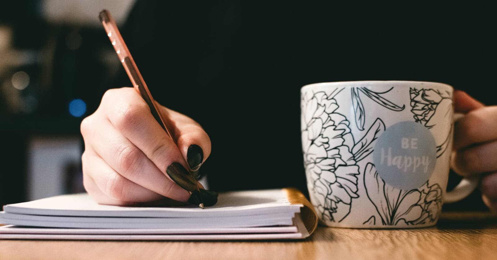 Писатель работает с блокнотом и кружкой