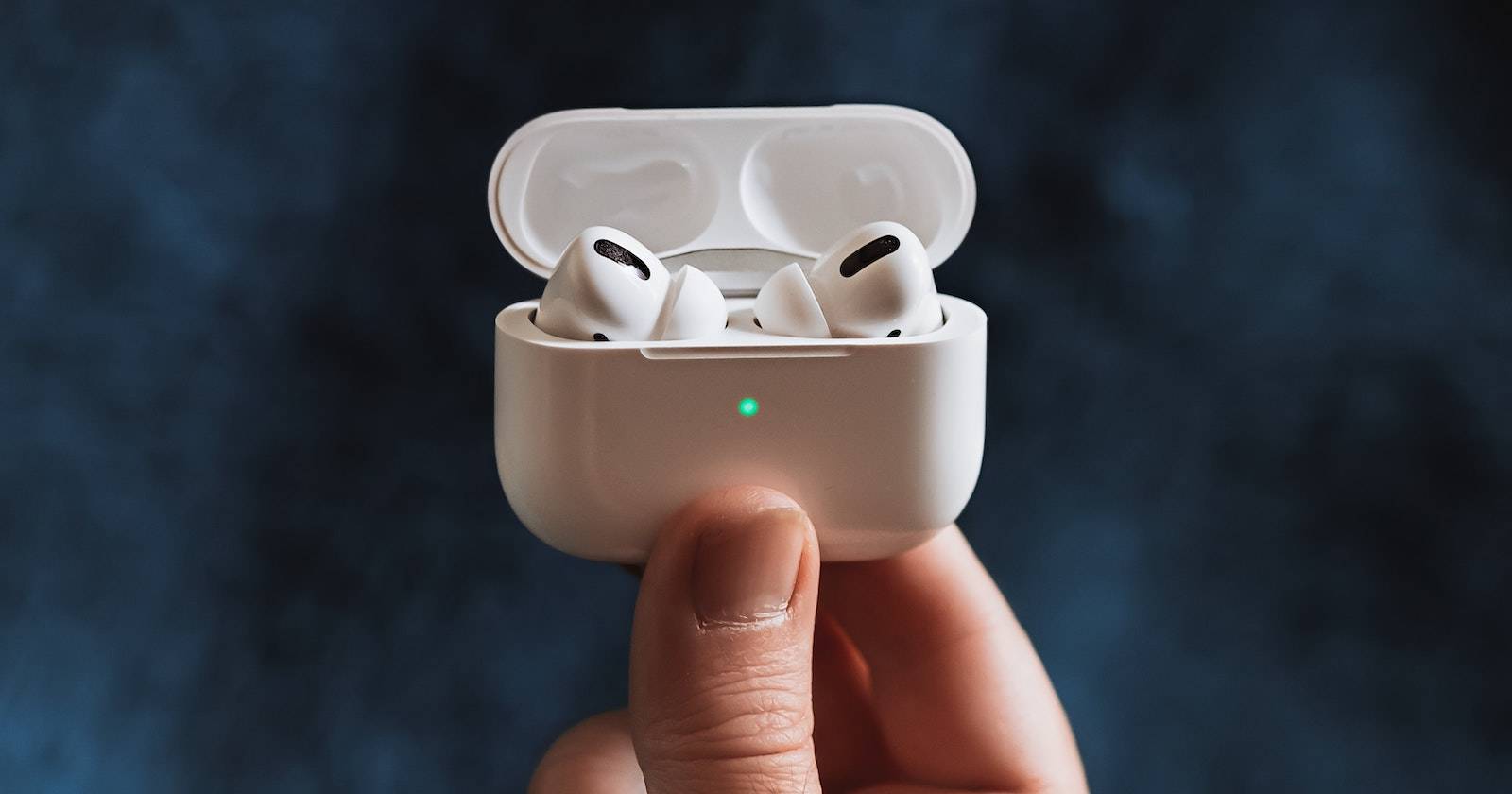 Человек держит AirPods Pro в руке