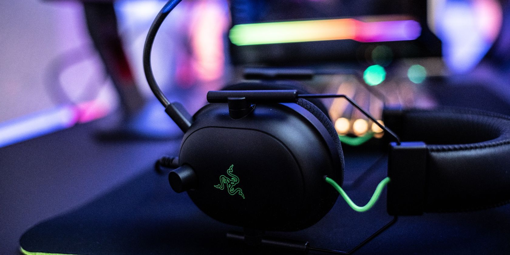 Green and Black Razer Headset Sitting on Mousepad on Gamer’s Desk
