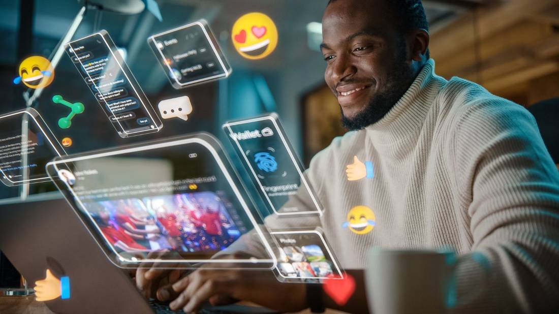 Мужчина сидит за ноутбуком, вокруг проецируются иконки социальных сетей