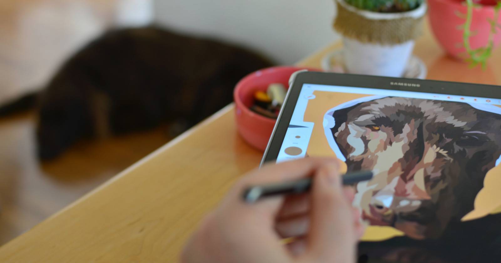 Человек рисует на планшете изображение собаки