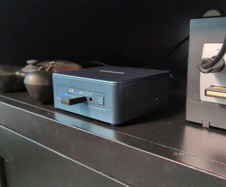 A mini PC with a Steam Controller and a Gamecube in an entertainment center.
