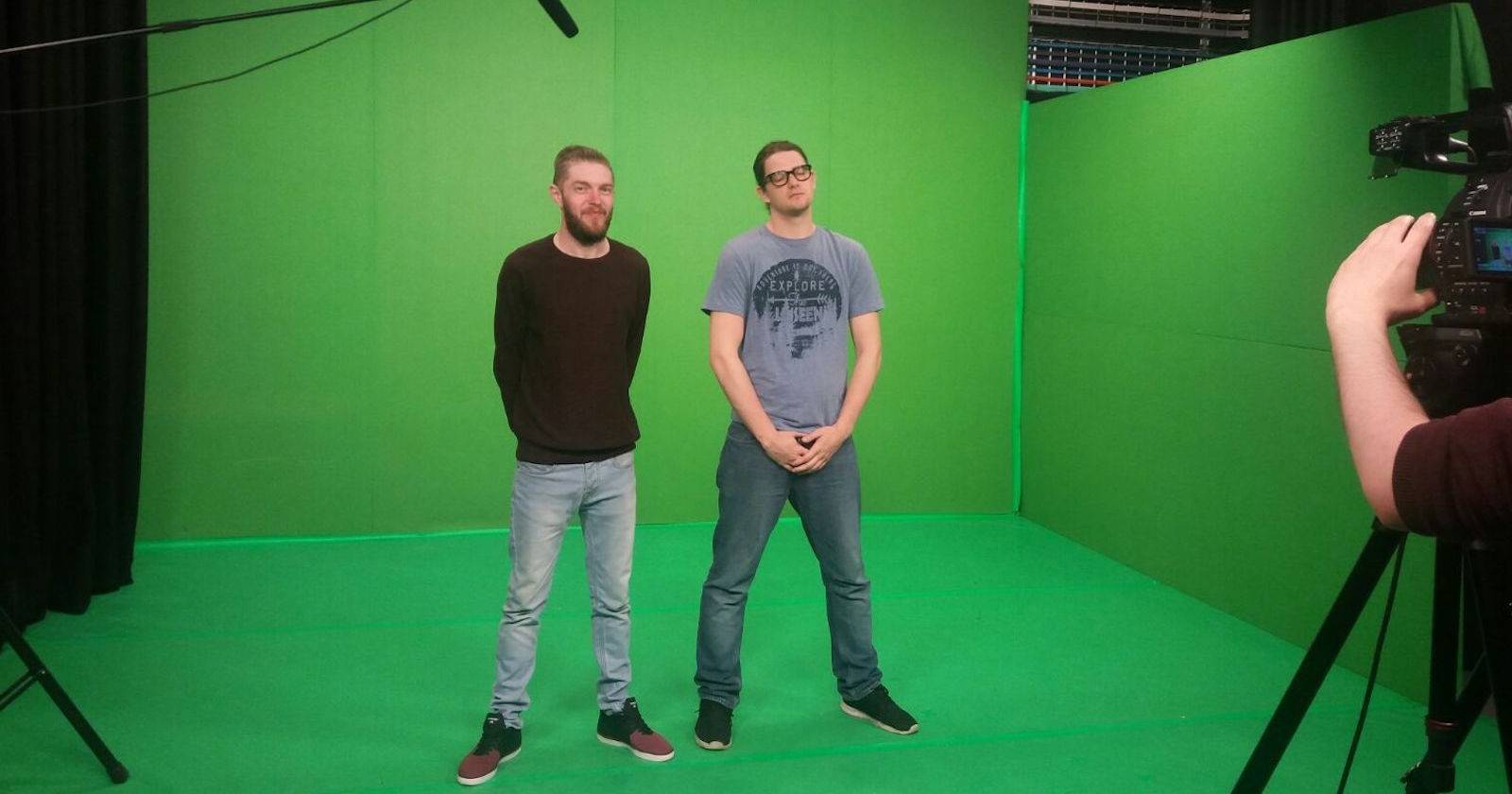 Два человека стоят перед зелёным экраном в студии