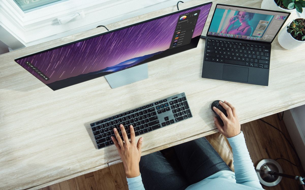 Человек с ноутбуком упорядочивает файлы на рабочем столе