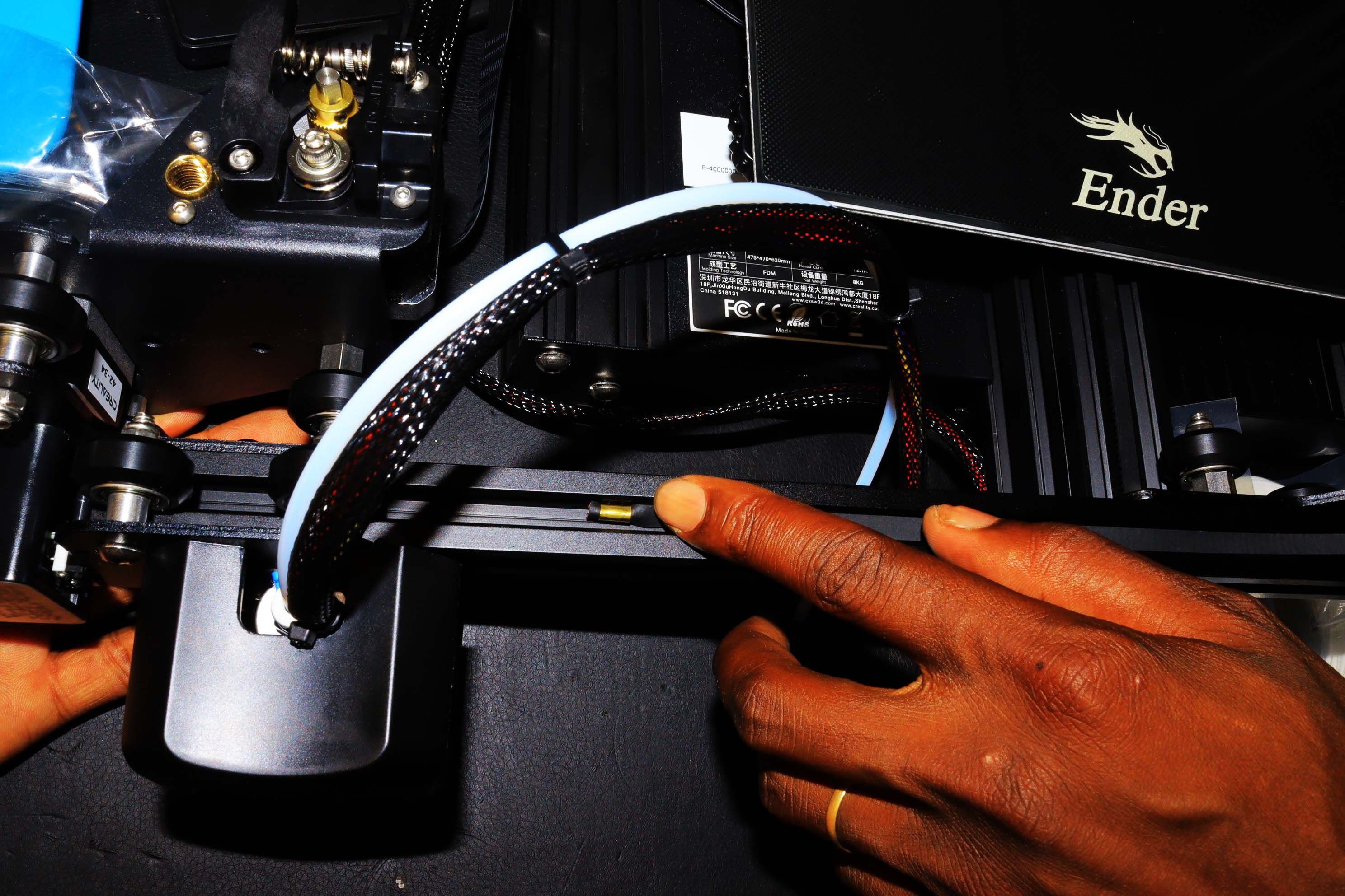 A hand placing the tightening belt to the printer