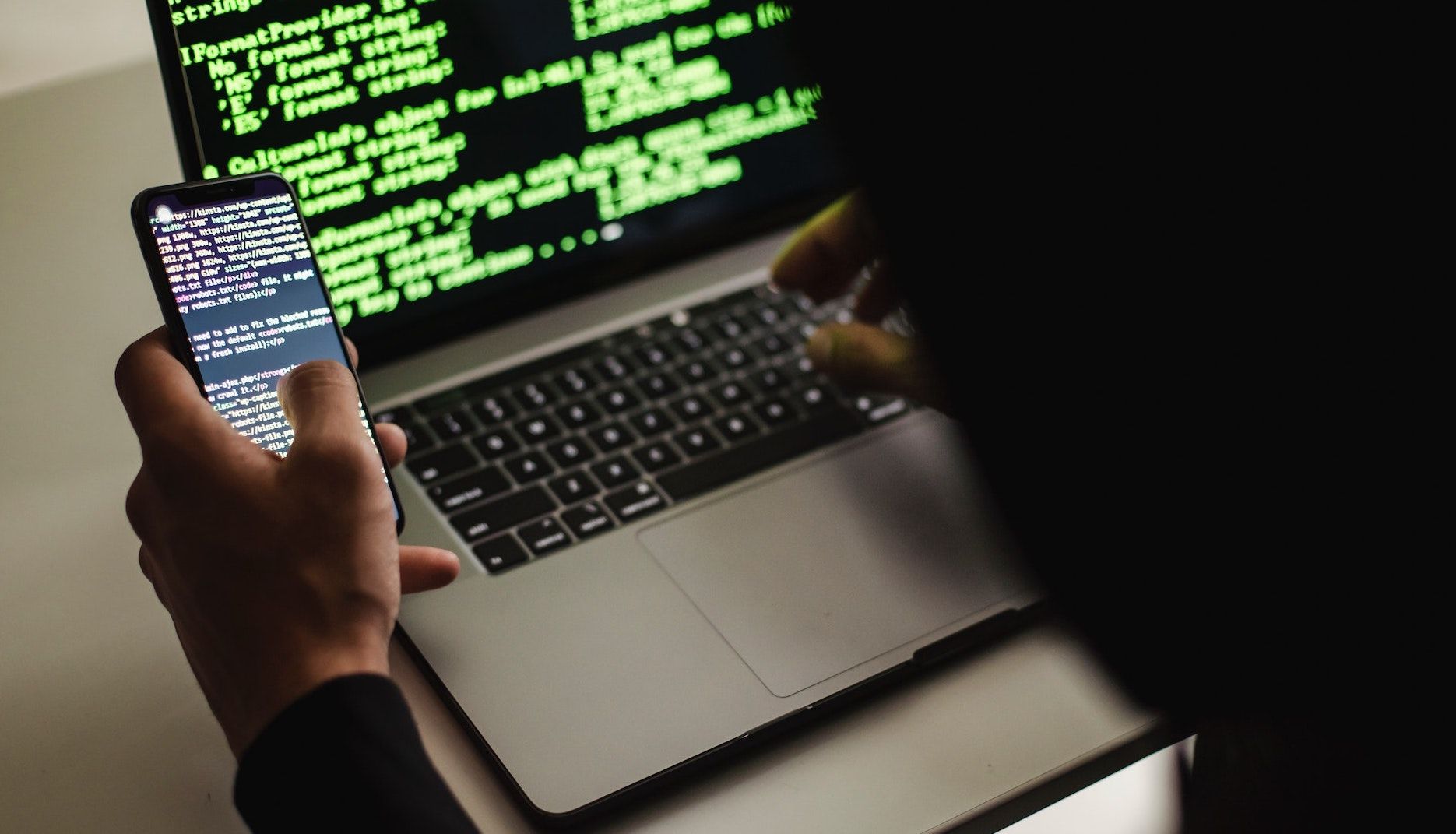 Пользователь с ноутбуком и телефоном, работающий в браузере