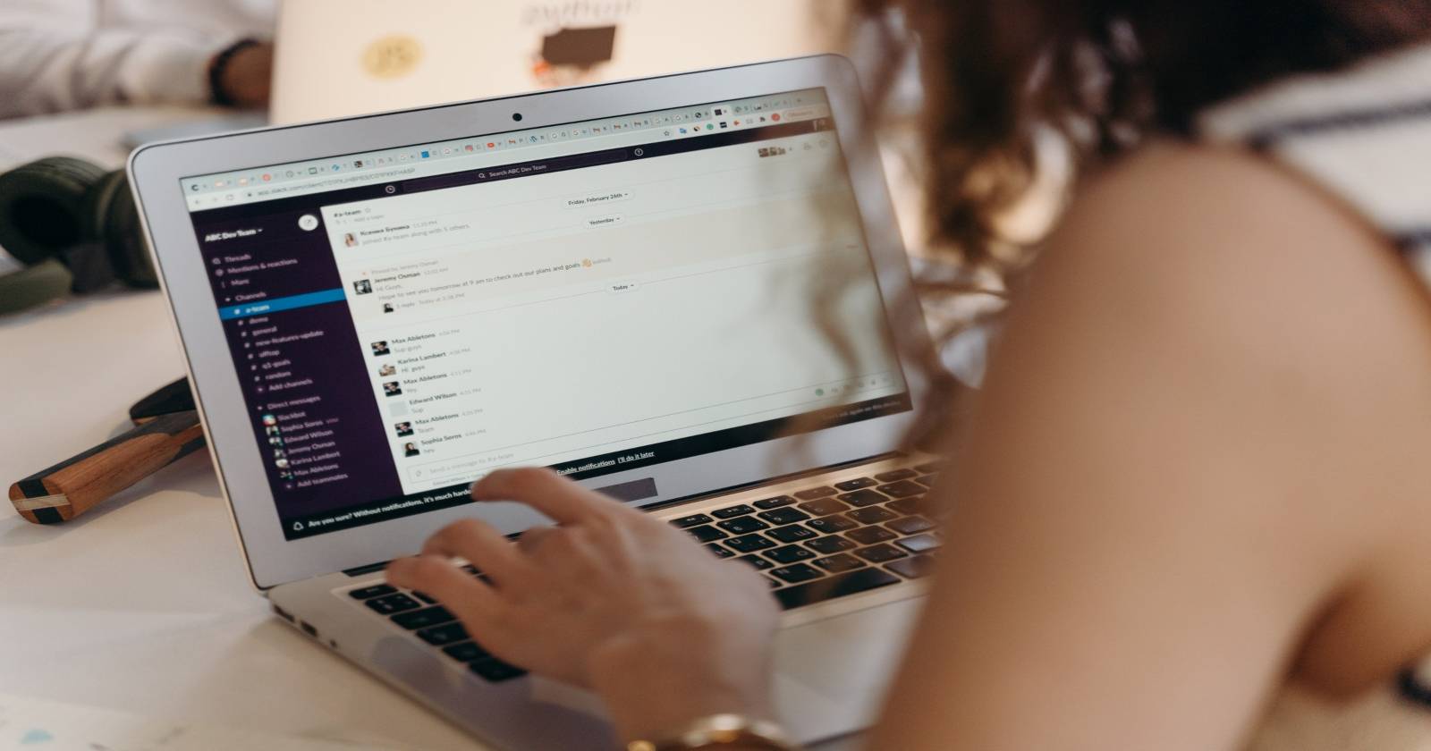 Женщина использует Slack на MacBook