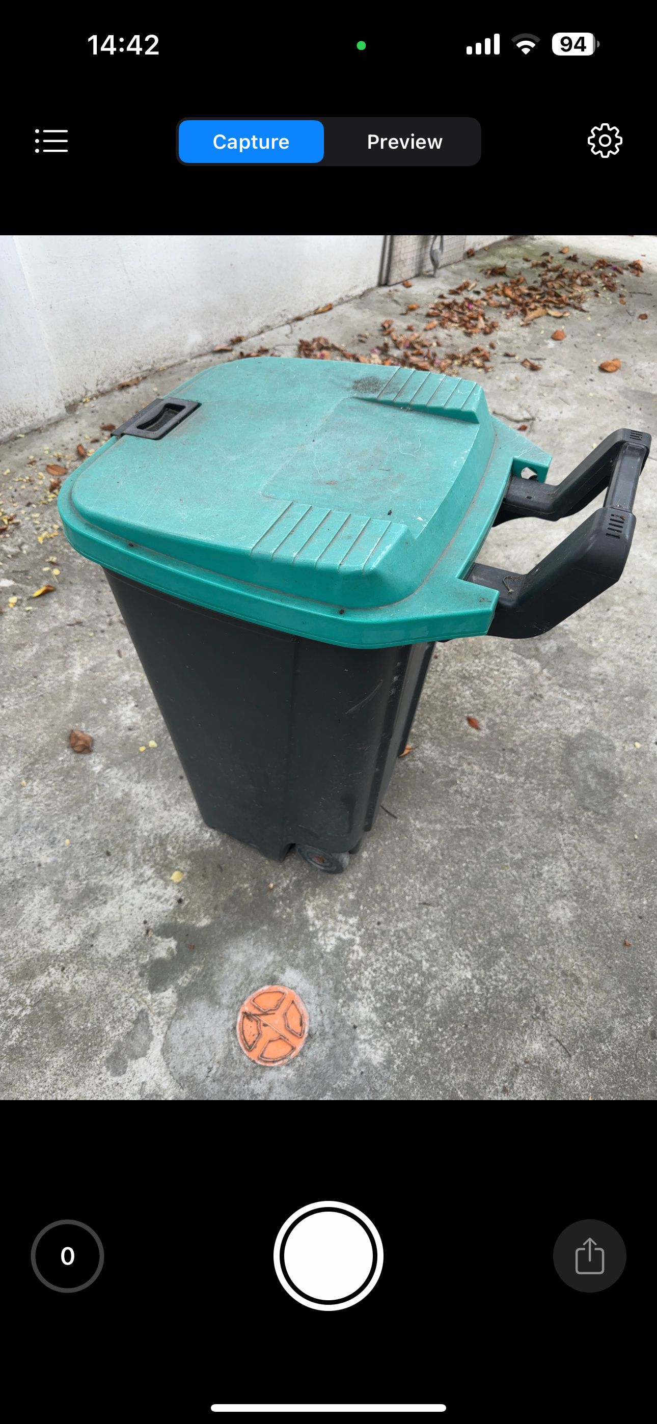 Green and black trash can under the shade