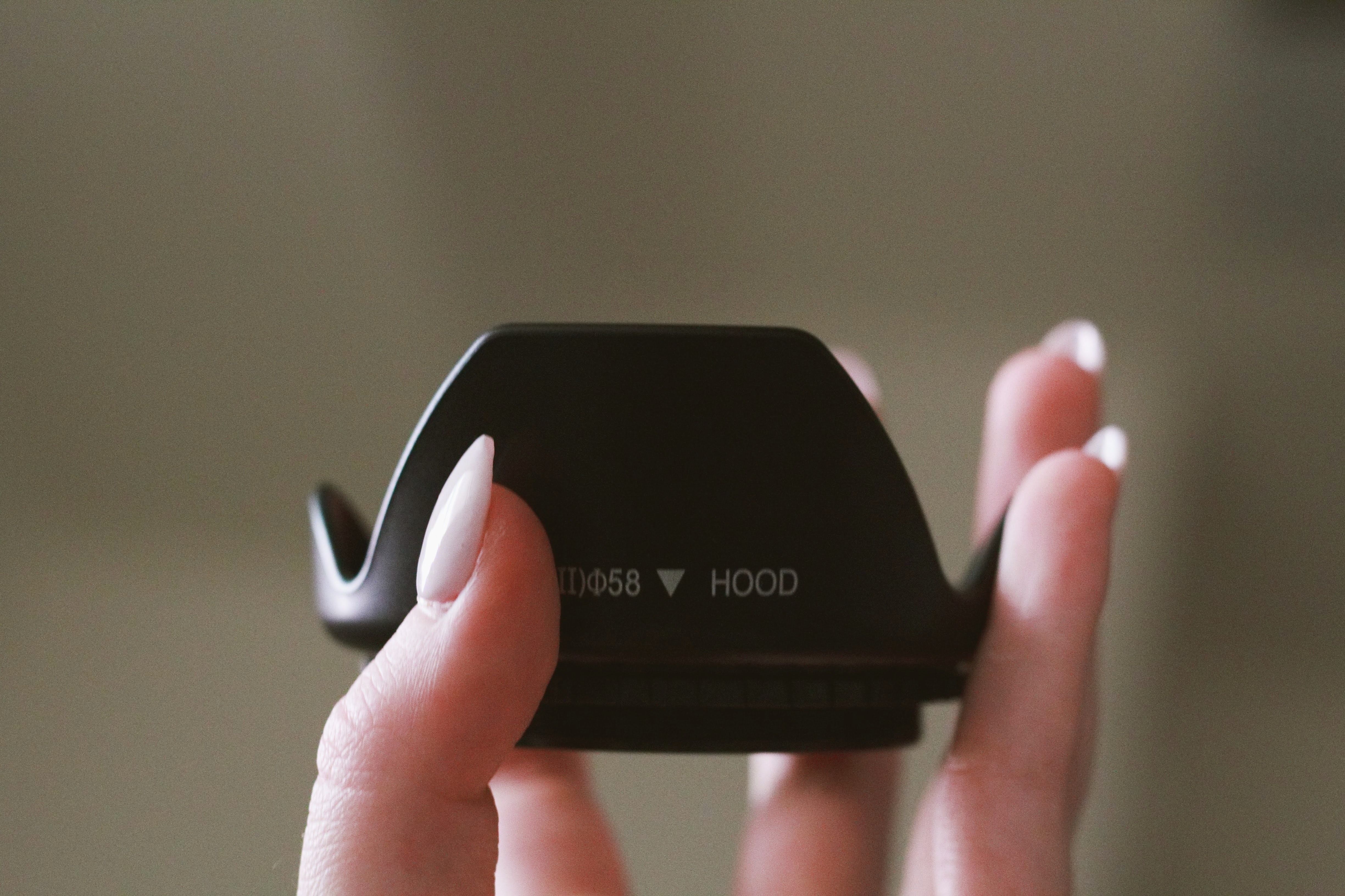 Фотограф прикрывает объектив блендой у стекла