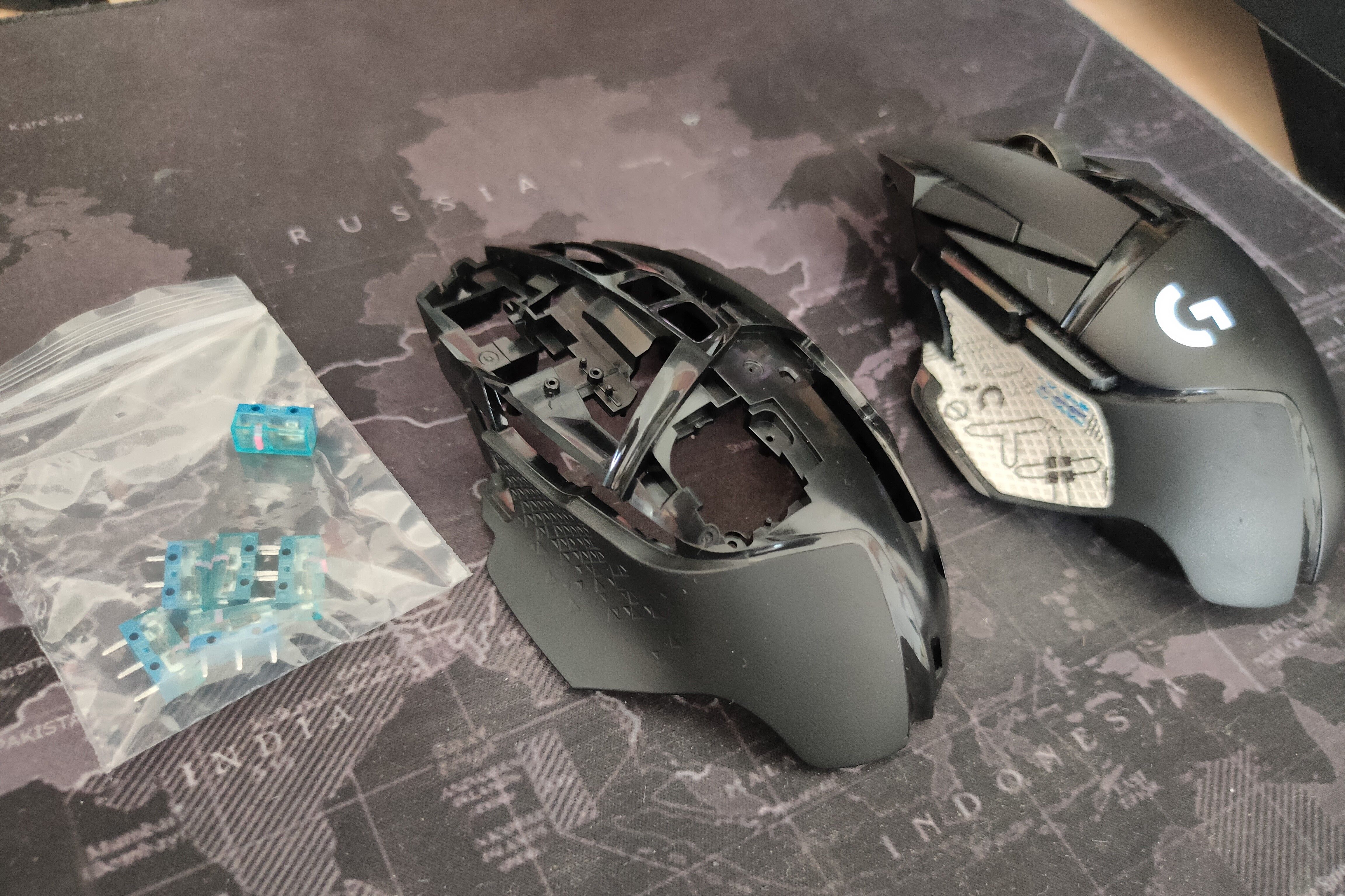 Logitech G502 Lightspeed рядом с запасной оболочкой и микропереключателями.
