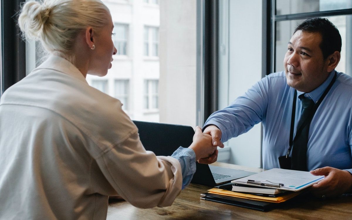 Два человека пожимают руки в офисной обстановке