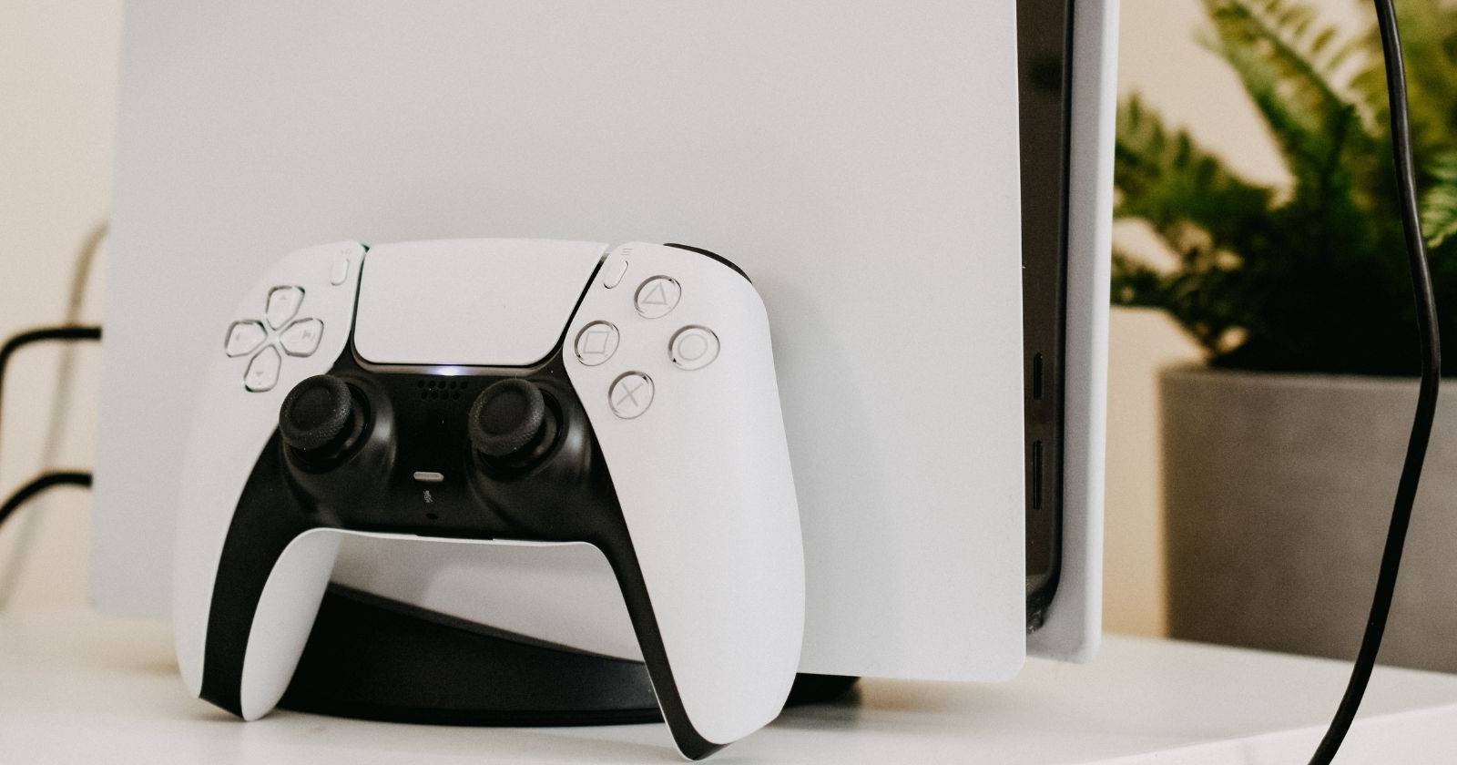 PS5 и контроллер DualSense в хорошо освещённой комнате 