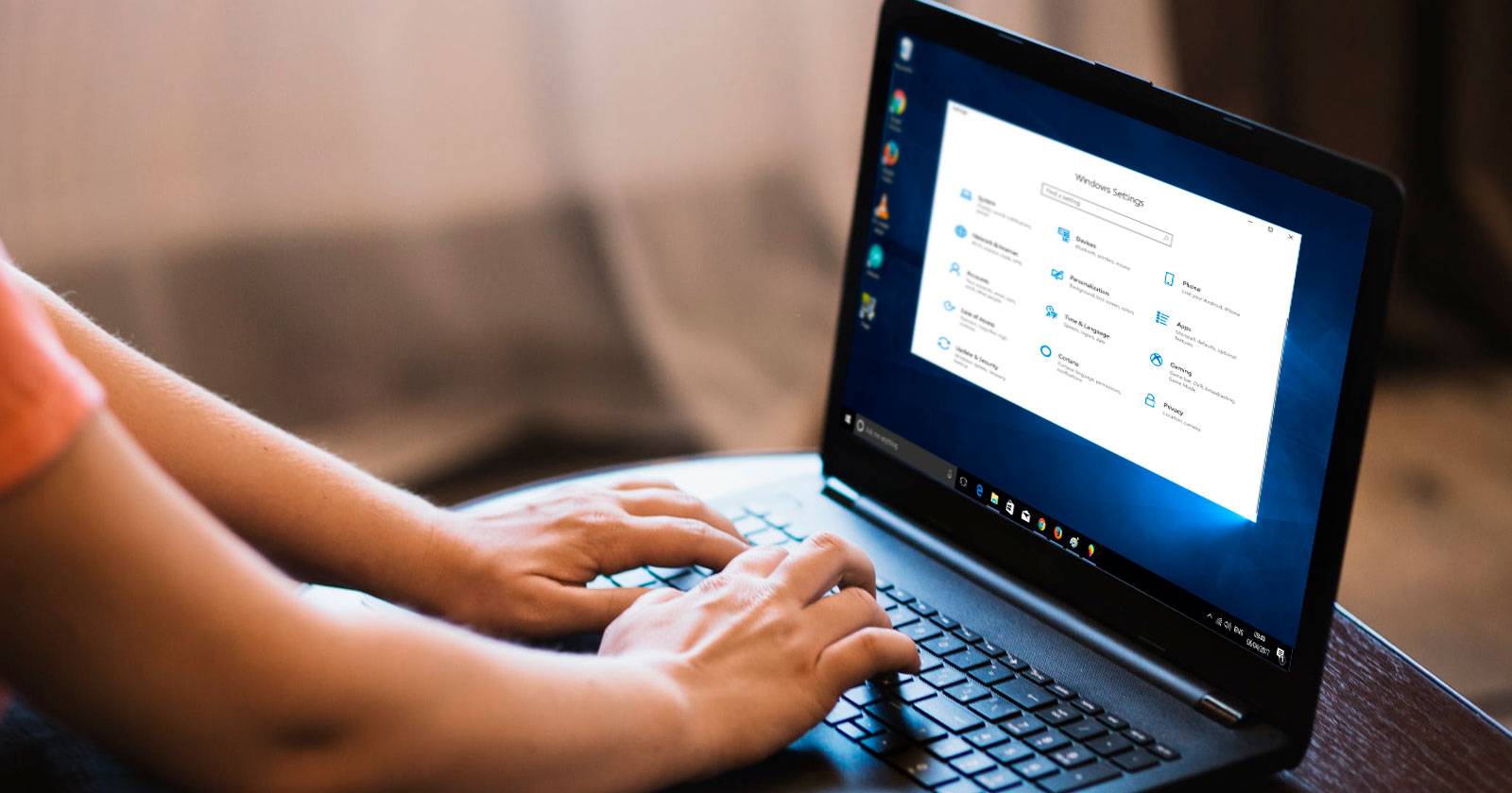 Человек использует ноутбук с Windows на маленьком столике