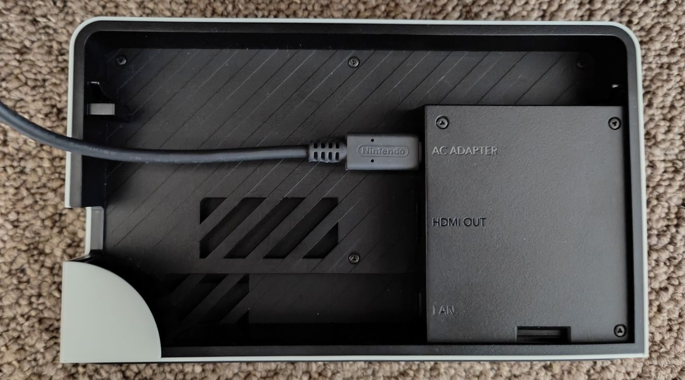 A photograph of the back ports of a Nintendo Switch OLED Dock with the AC Adapter plugged in