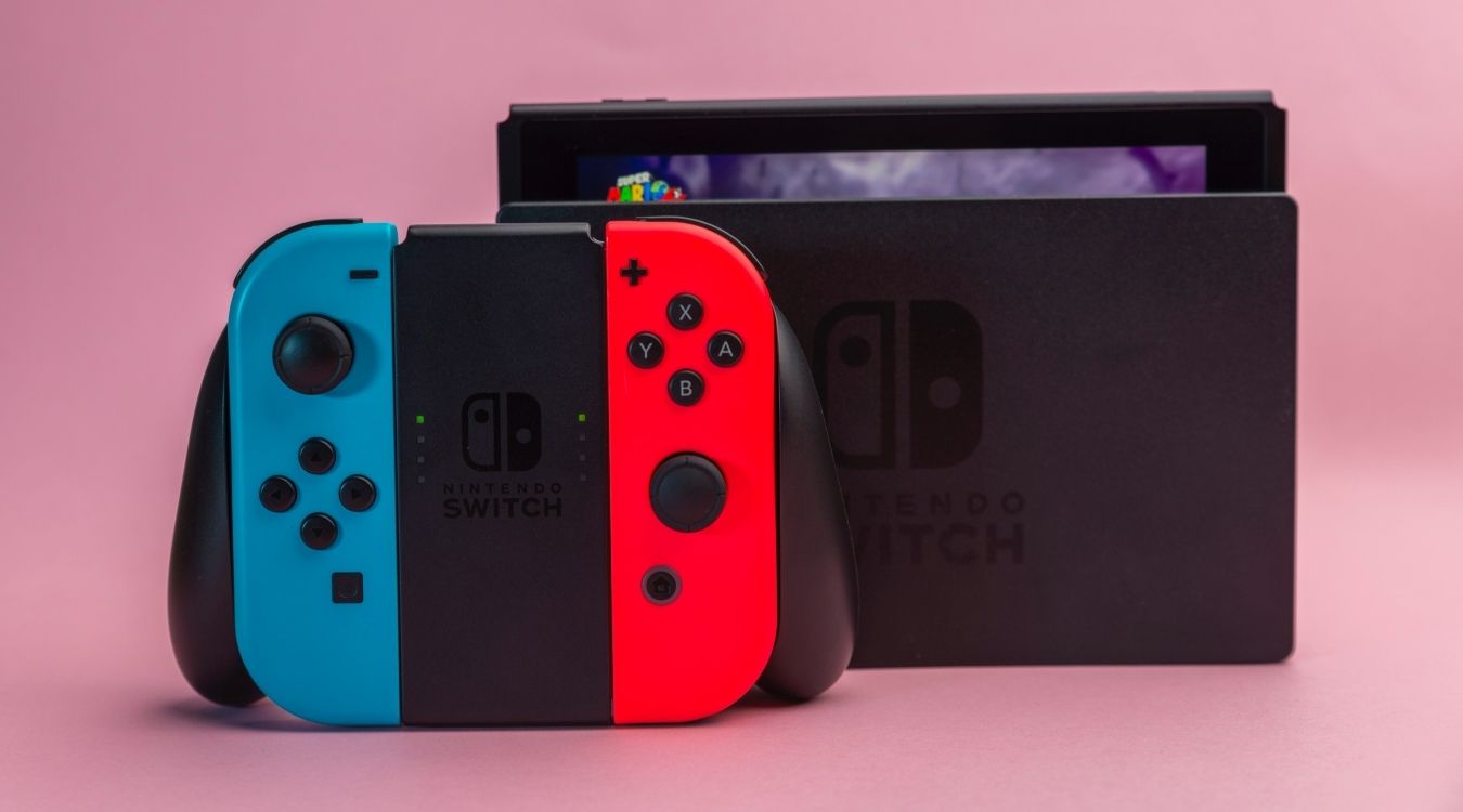 A photograph fo a Nintendo Switch console in a Dock with Joy Cons resting in front of the console