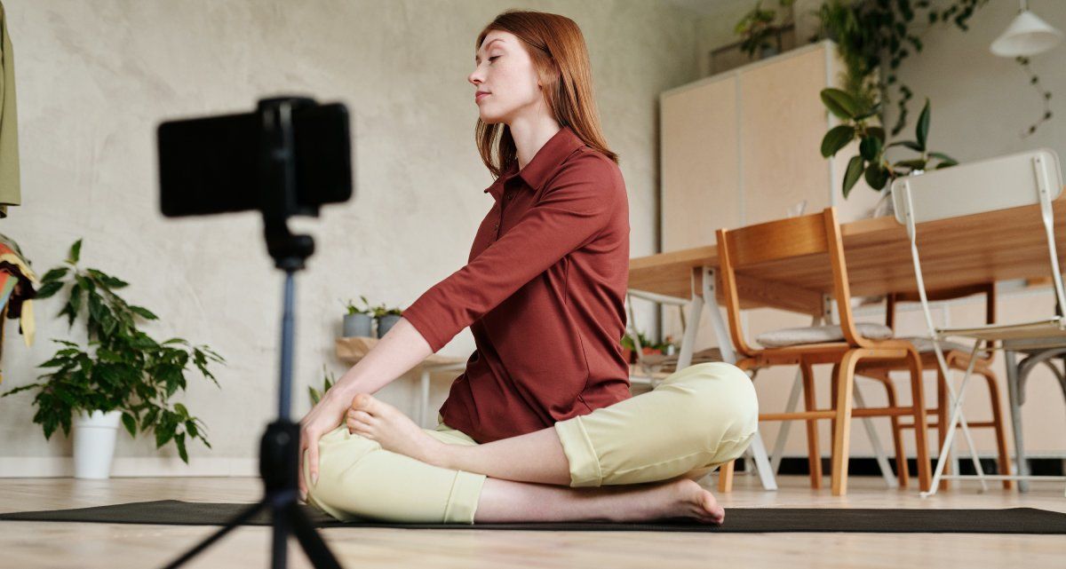 Человек занимается йогой и записывает видео