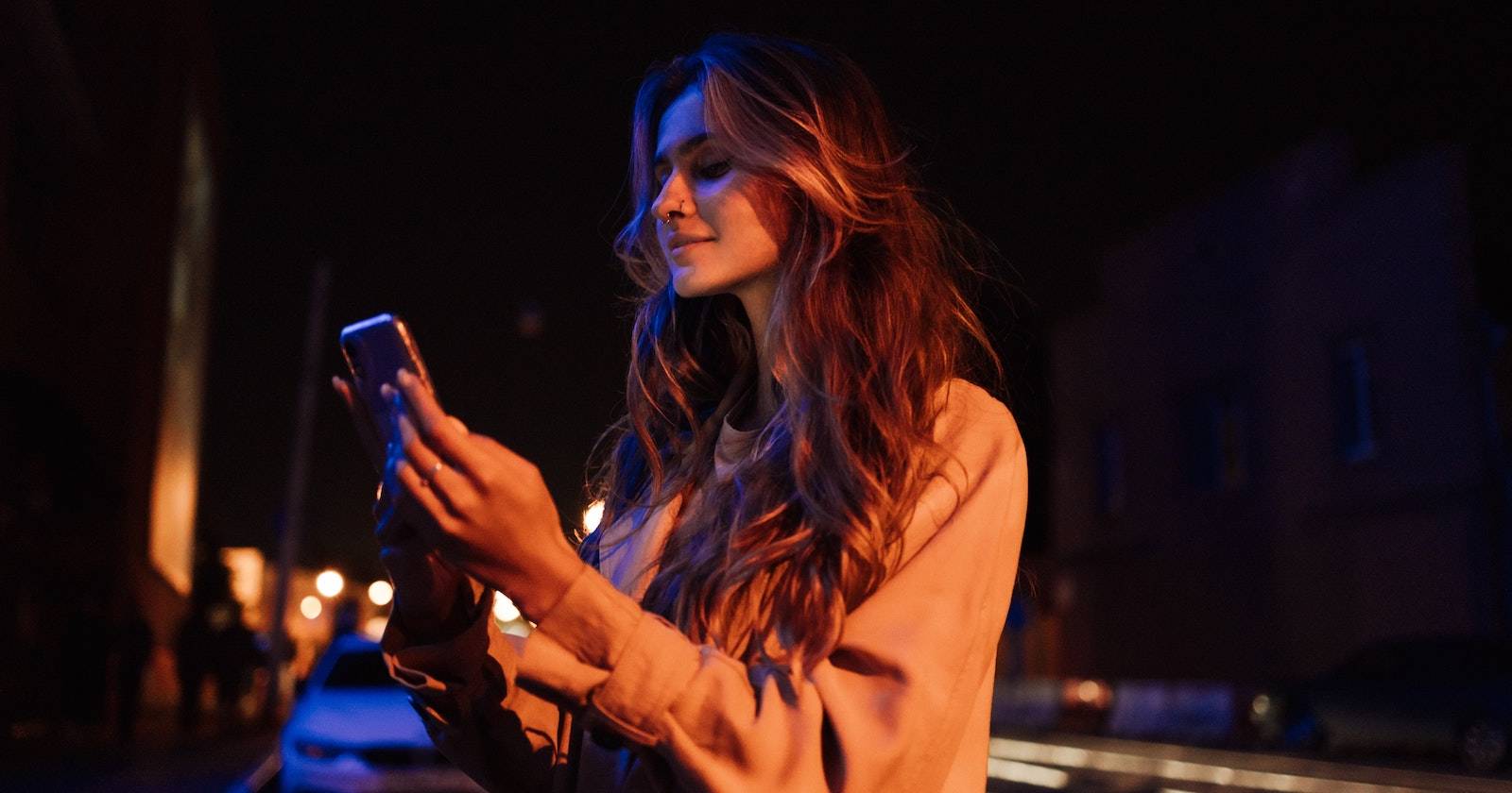 Женщина ночью смотрит в смартфон при синем свете