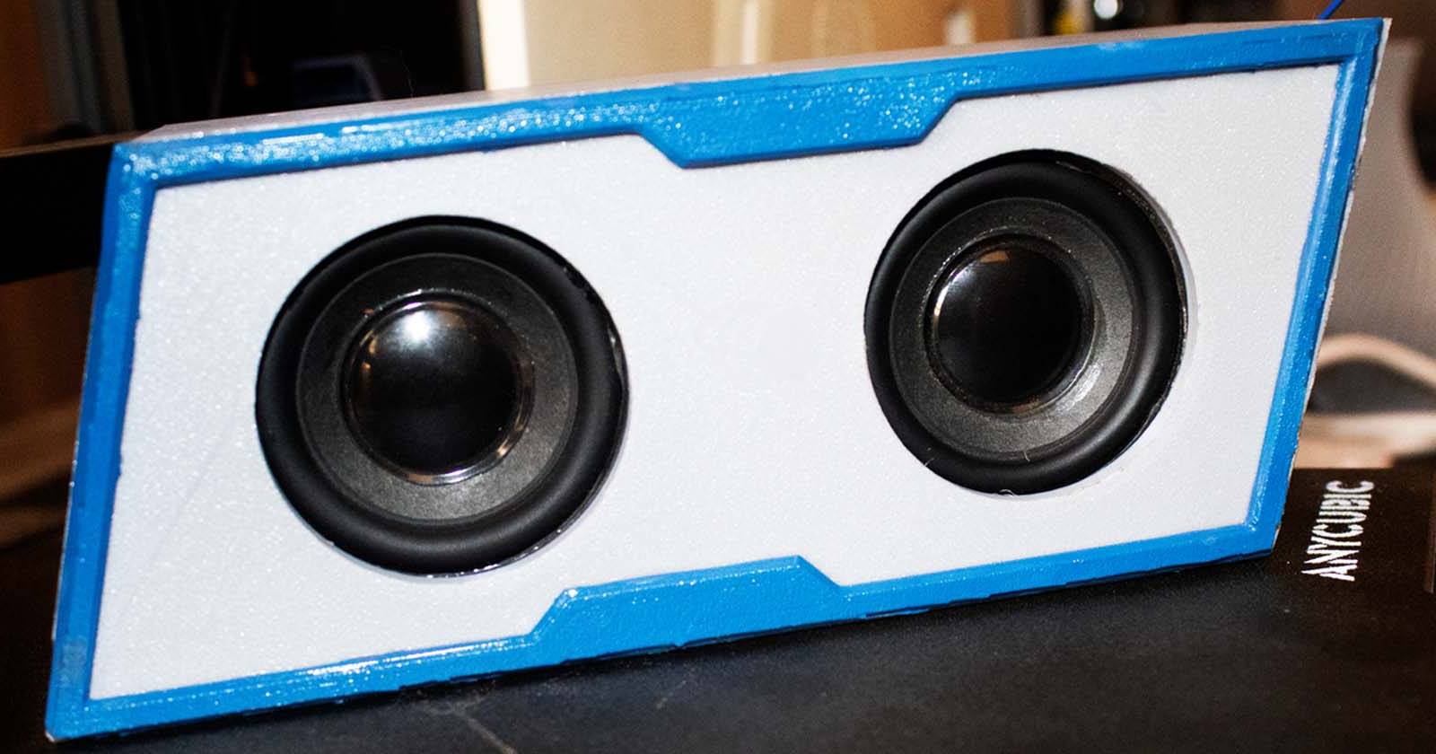 A bluetooth speaker on top of a 3D printer bed