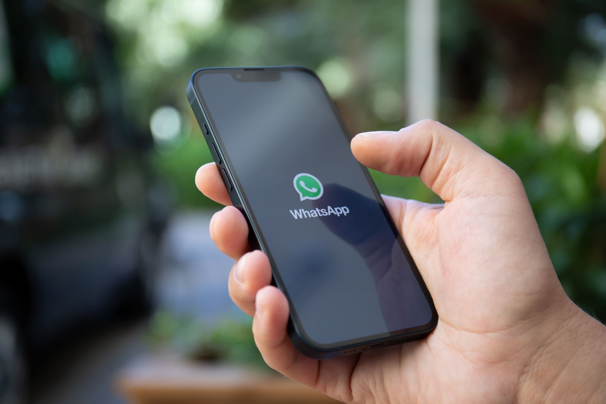 Человек использует смартфон с логотипом WhatsApp на экране