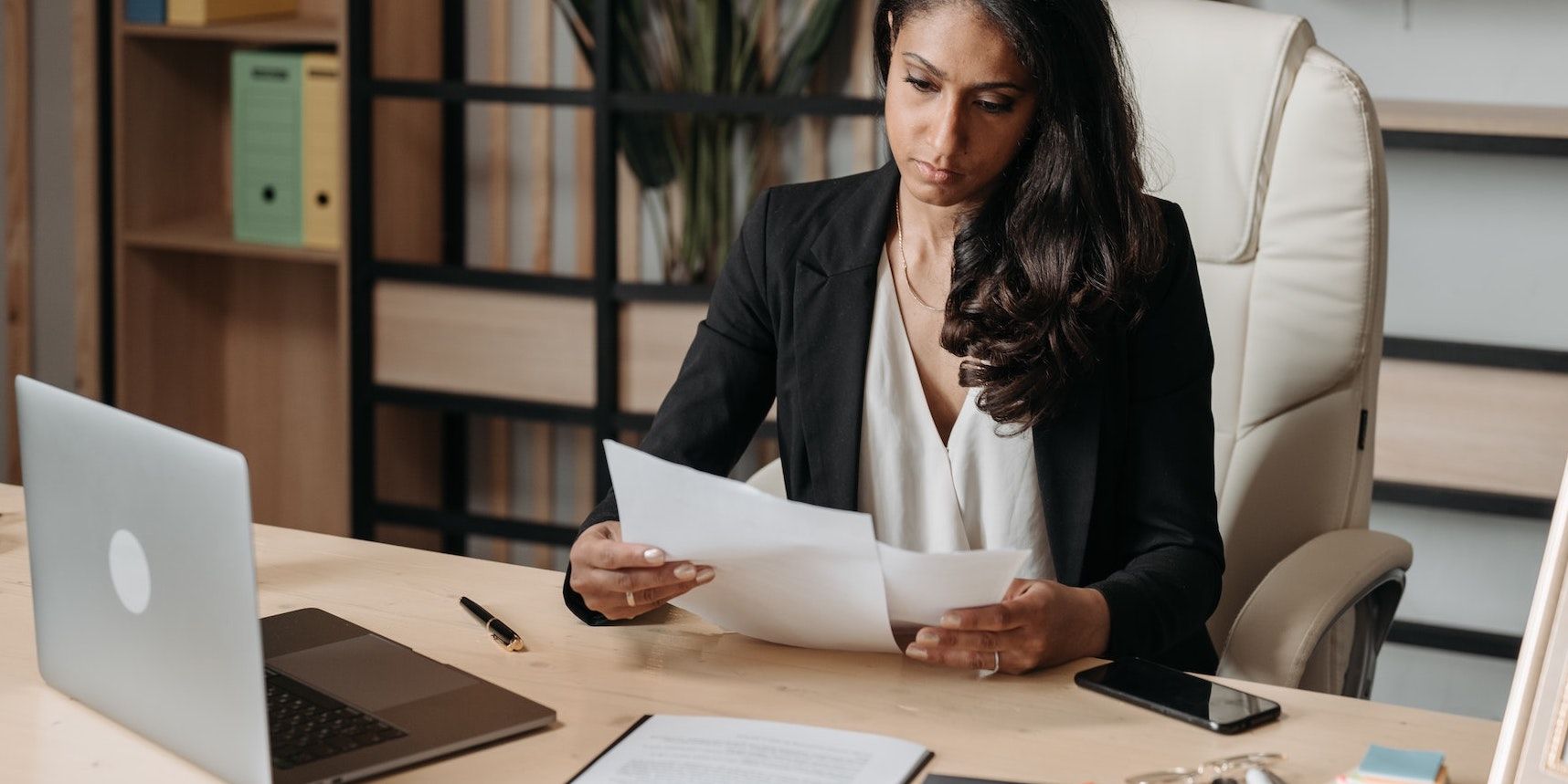 Женщина просматривает бумаги в офисе