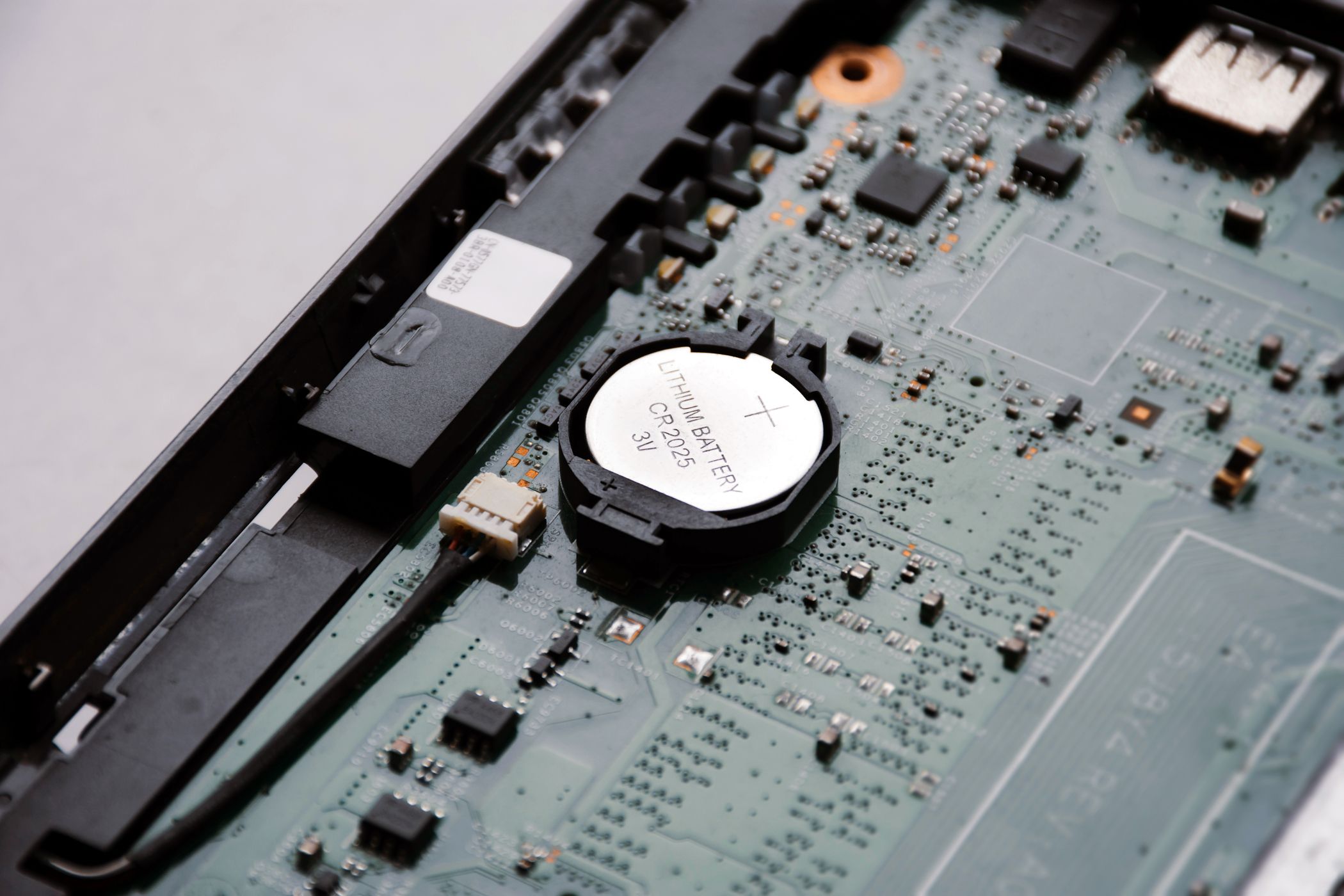 Батарейка CMOS на материнской плате рядом с другими компонентами.