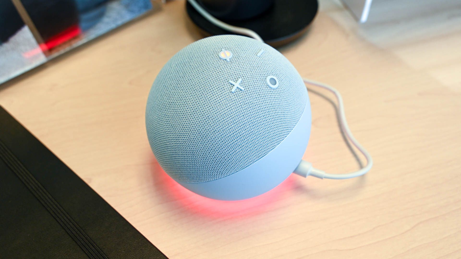Echo Dot 5-го поколения с включённым режимом «mute», устройство стоит на столе.
