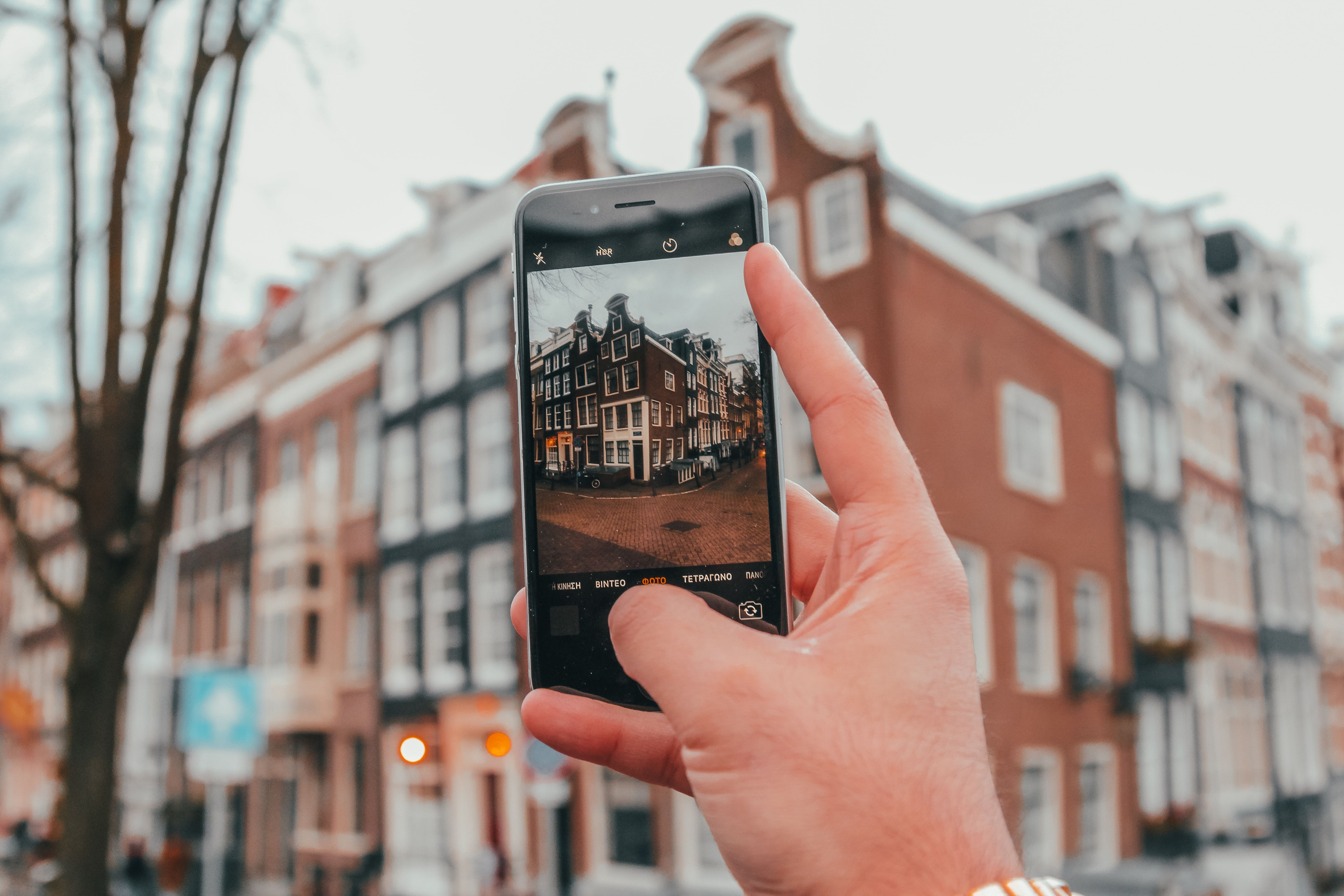 Человек фотографирует на смартфон, другой фотографирует их