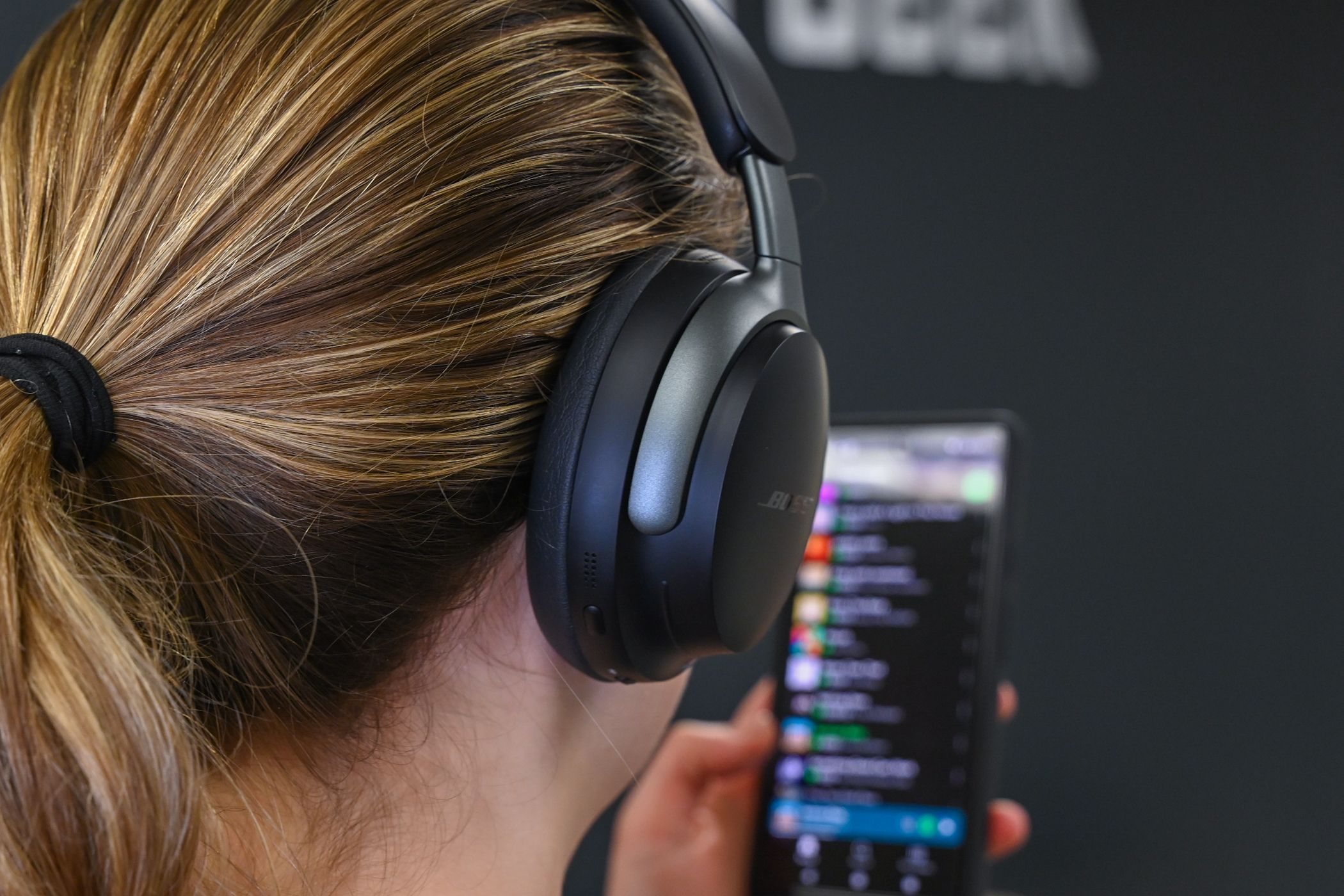 Человек слушает музыку в наушниках Bose QuietComfort Ultra.