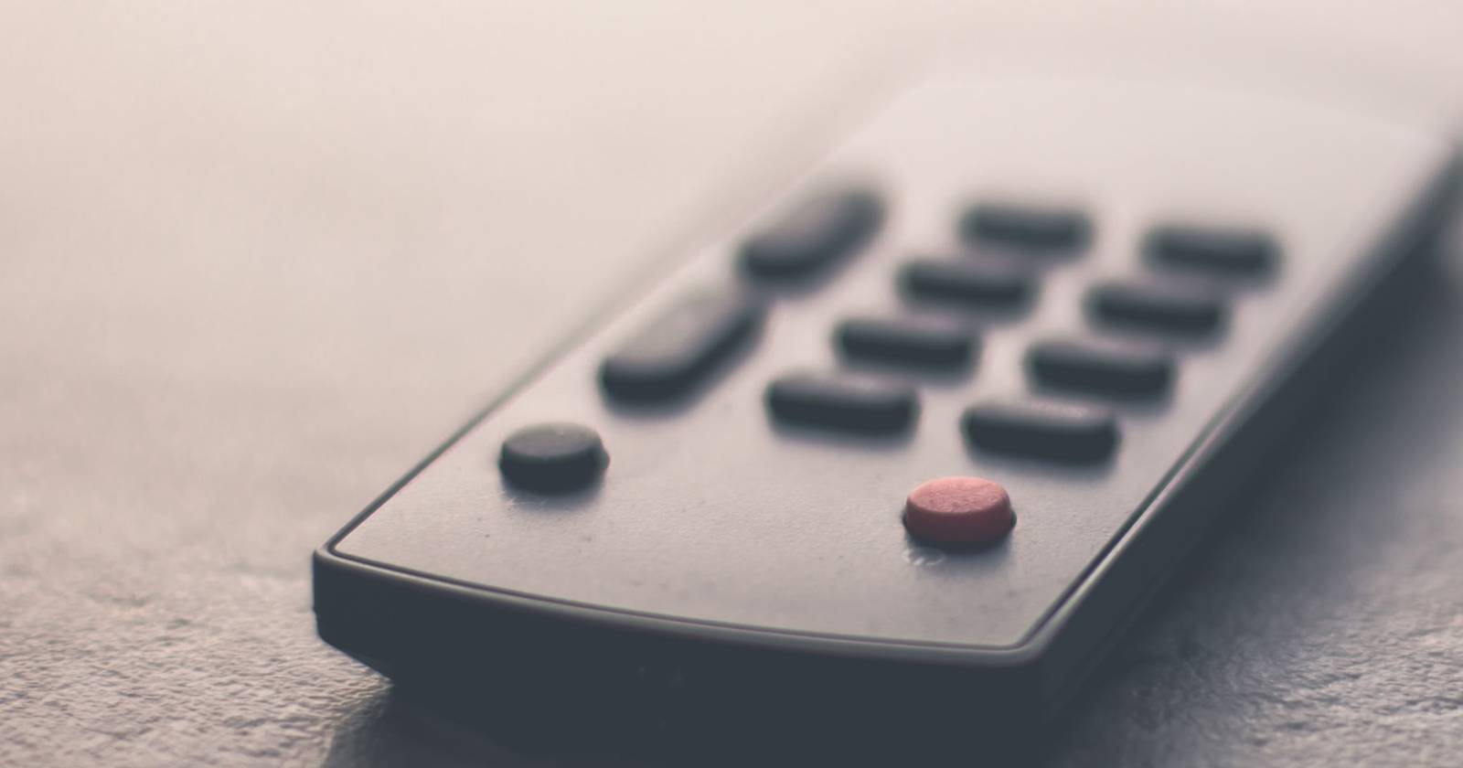 Пульт дистанционного управления лежит на плоской поверхности