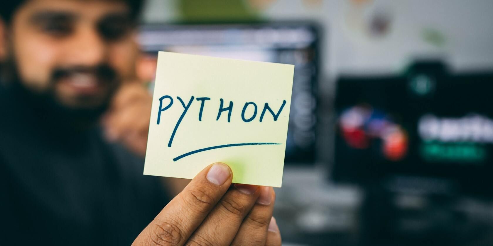 Человек держит карточку с логотипом Python