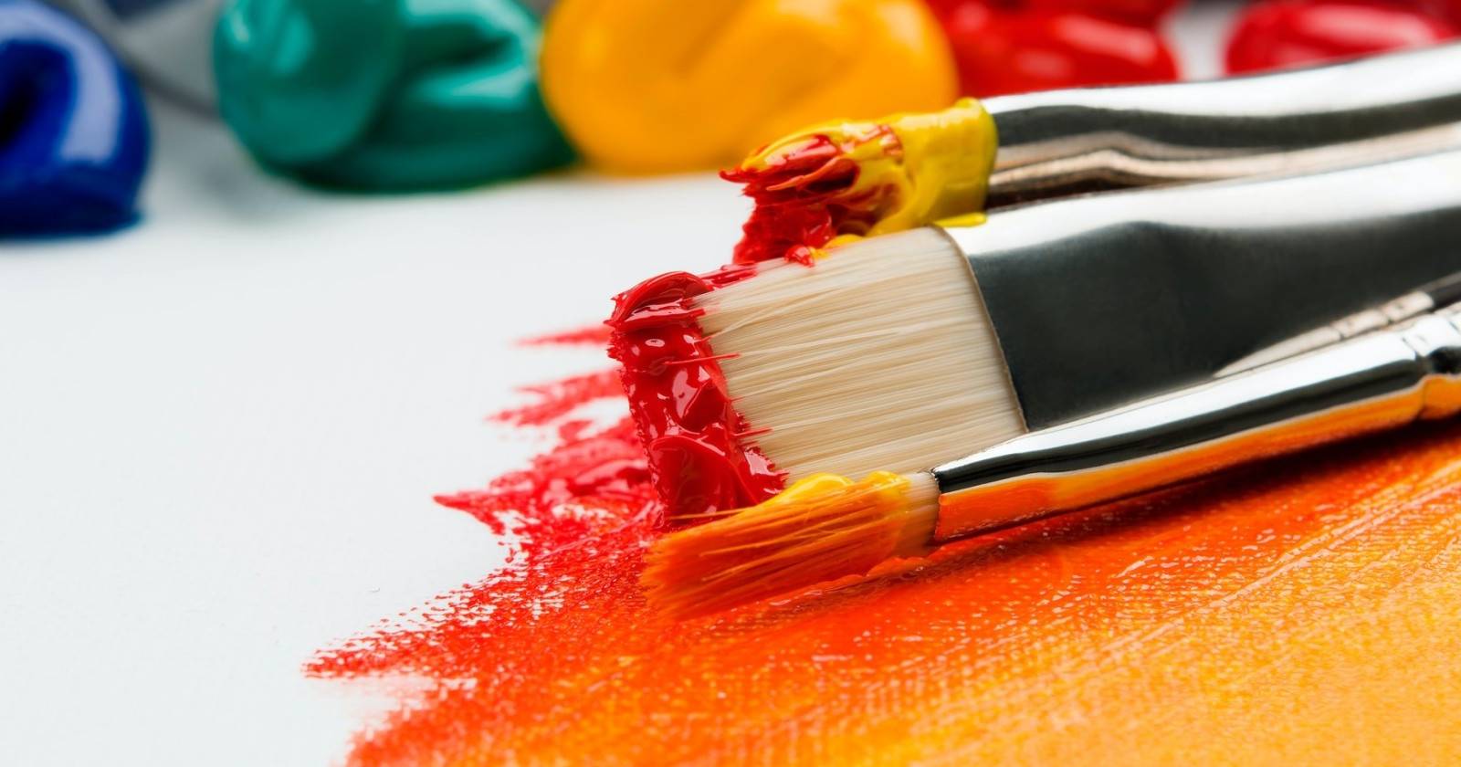 Кисть для краски с разноцветными пятнами краски на щетине