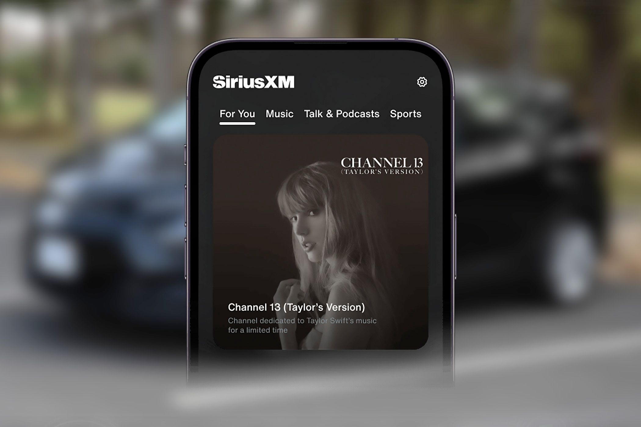 Телефон воспроизводит SiriusXM Channel 13 на фоне машины.