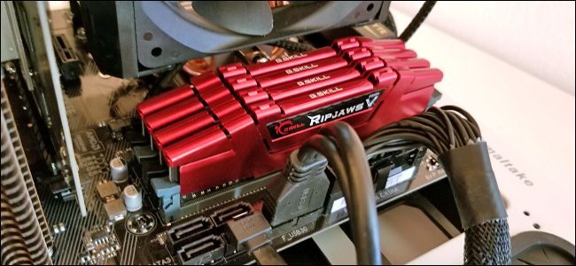 Four RAM sticks seated on a motherboard. 