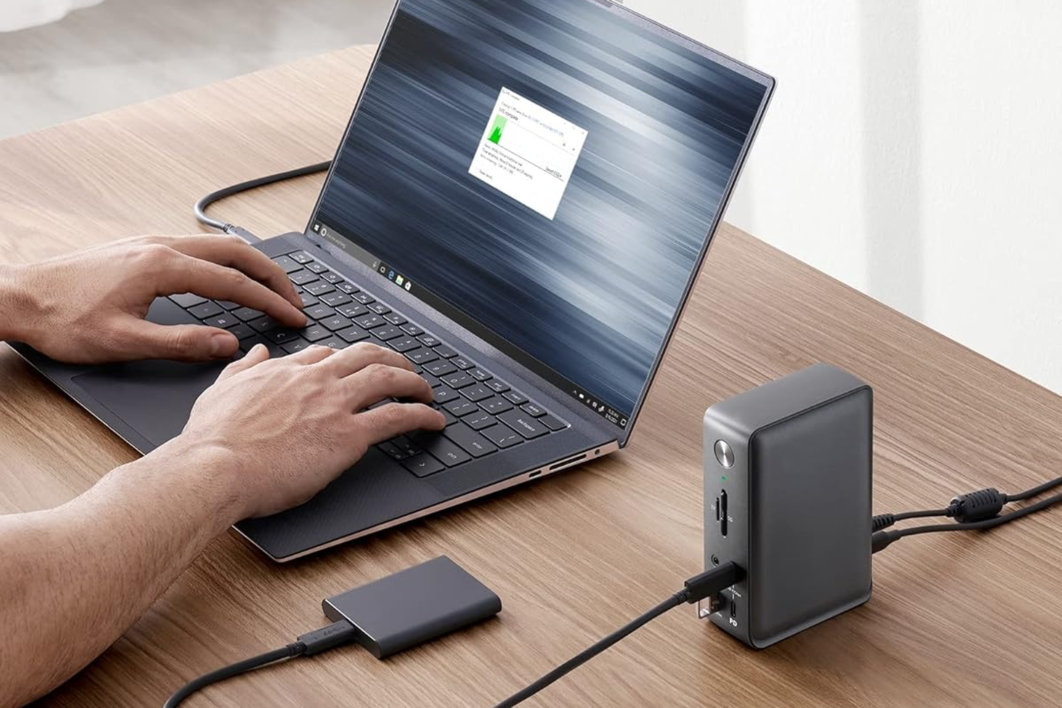 Anker 575 13‑in‑1 USB‑C hub sitting on a desk plugged into a laptop