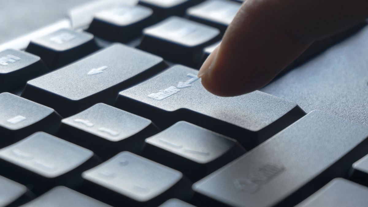 Палец нажимает клавишу Enter на клавиатуре