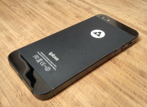 Фото: задняя панель телефона, частично срезанная наклейка логотипа