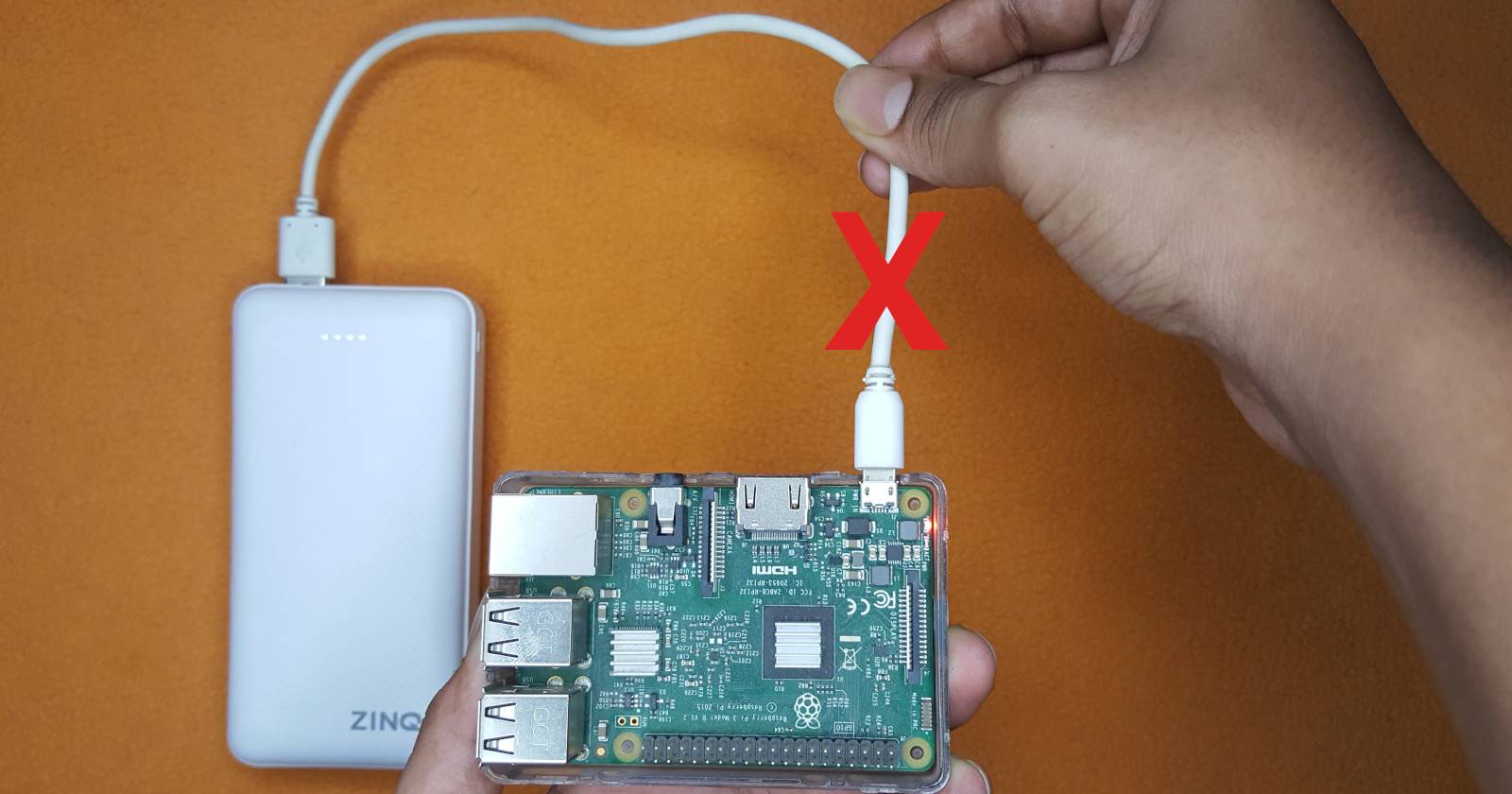 Raspberry Pi with hand holding the power cable