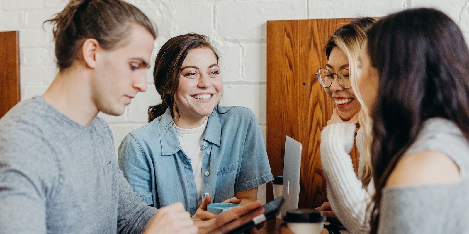 Четверо друзей улыбаются и смеются